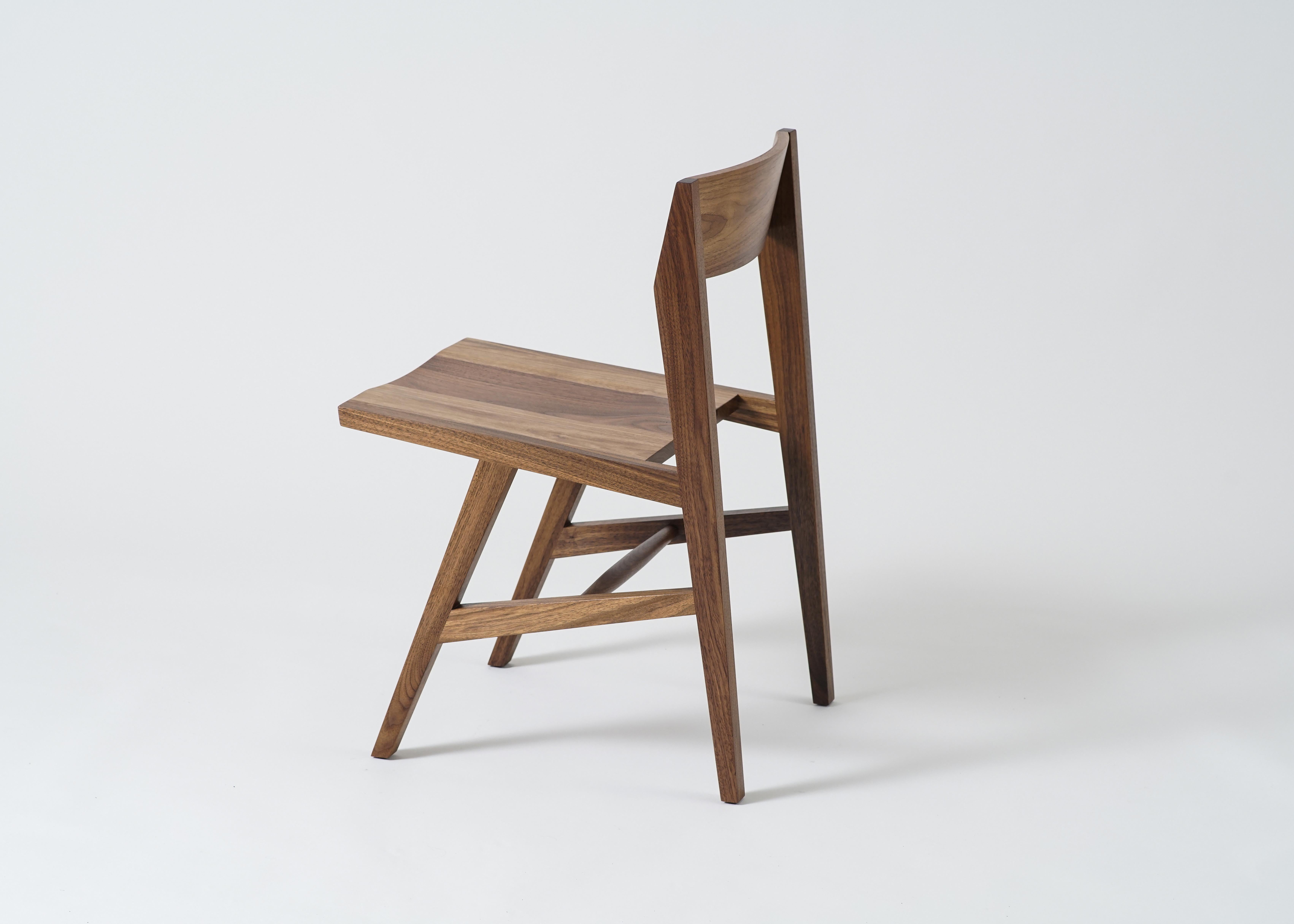 Der Jess Beistellstuhl von Phloem Studio ist ein moderner, zeitgemäßer Massivholz-Esszimmerstuhl aus weißer Eiche mit konisch zulaufenden Hartholzbeinen und einer geschwungenen Rückenlehne aus laminiertem Massivholz. Der Sitz hat ein geschnitztes