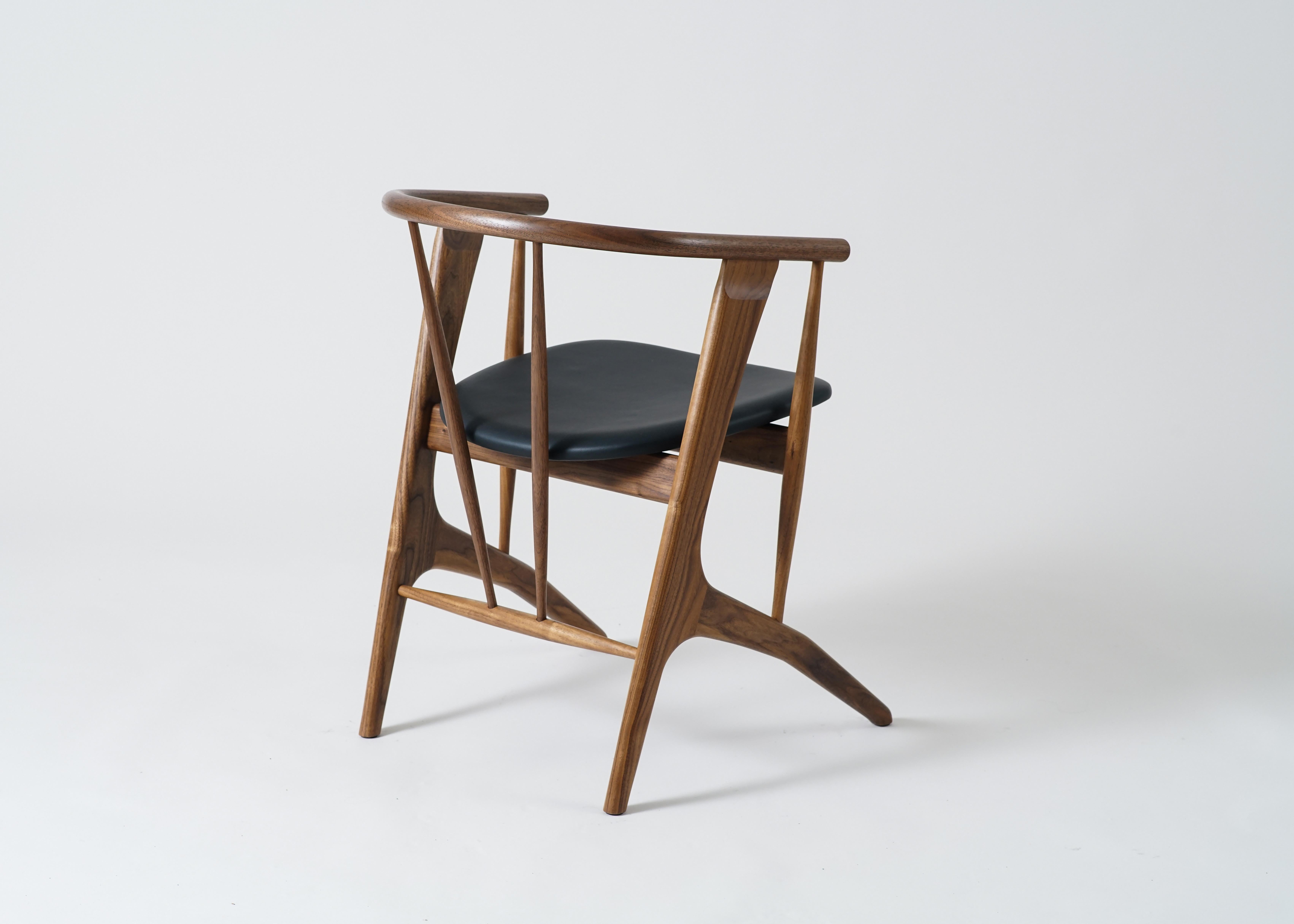 Le fauteuil Zoe de Phloem Studio est un fauteuil moderne et contemporain en bois massif fabriqué à la main sur commande. Zoe est un fauteuil léger très bien conçu et très confortable, conçu pour les longs dîners ou les soirées de travail. Le dos