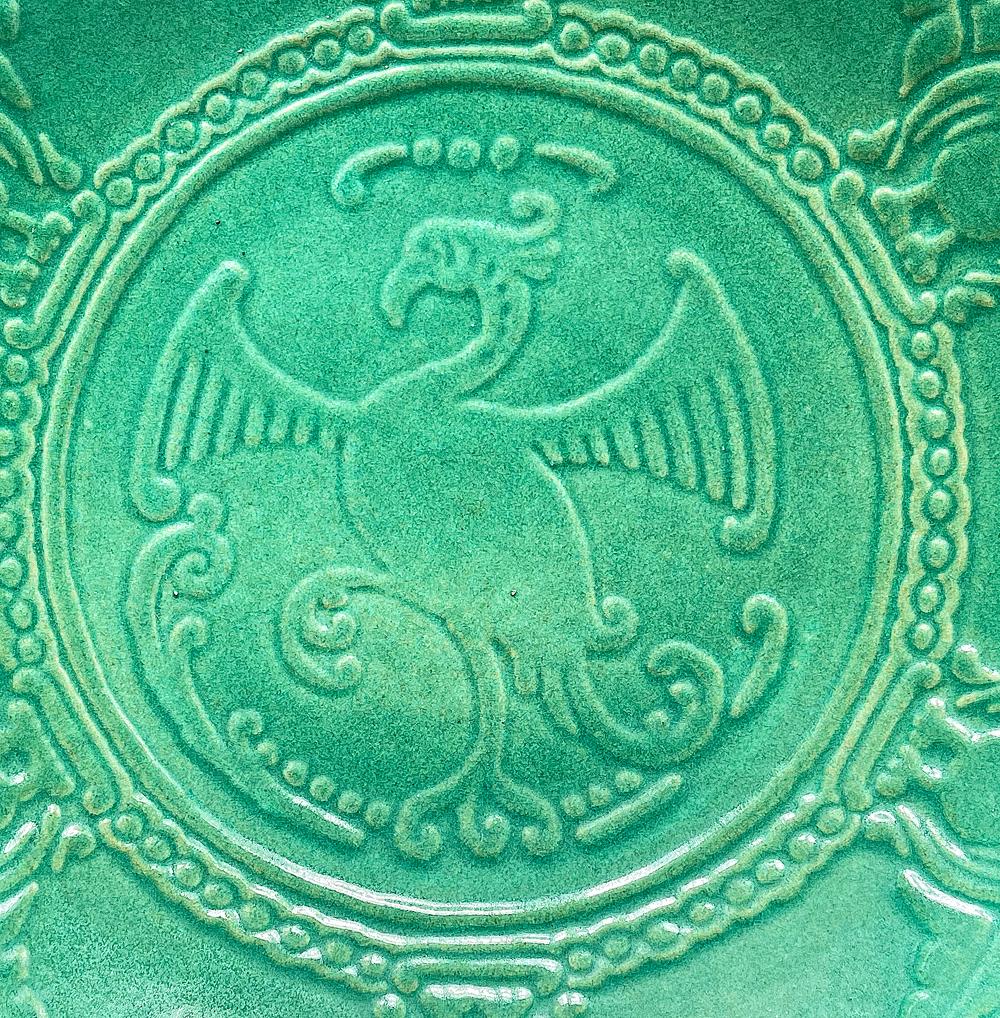 Baignant dans une glaçure vert jade vive et fraîche, cette grande et rare coupe basse représentant un oiseau Phoenix en son centre, les ailes déployées, a été conçue par Waylande Gregory pour Cowan Pottery.  Cowan a connu son plus grand succès à la