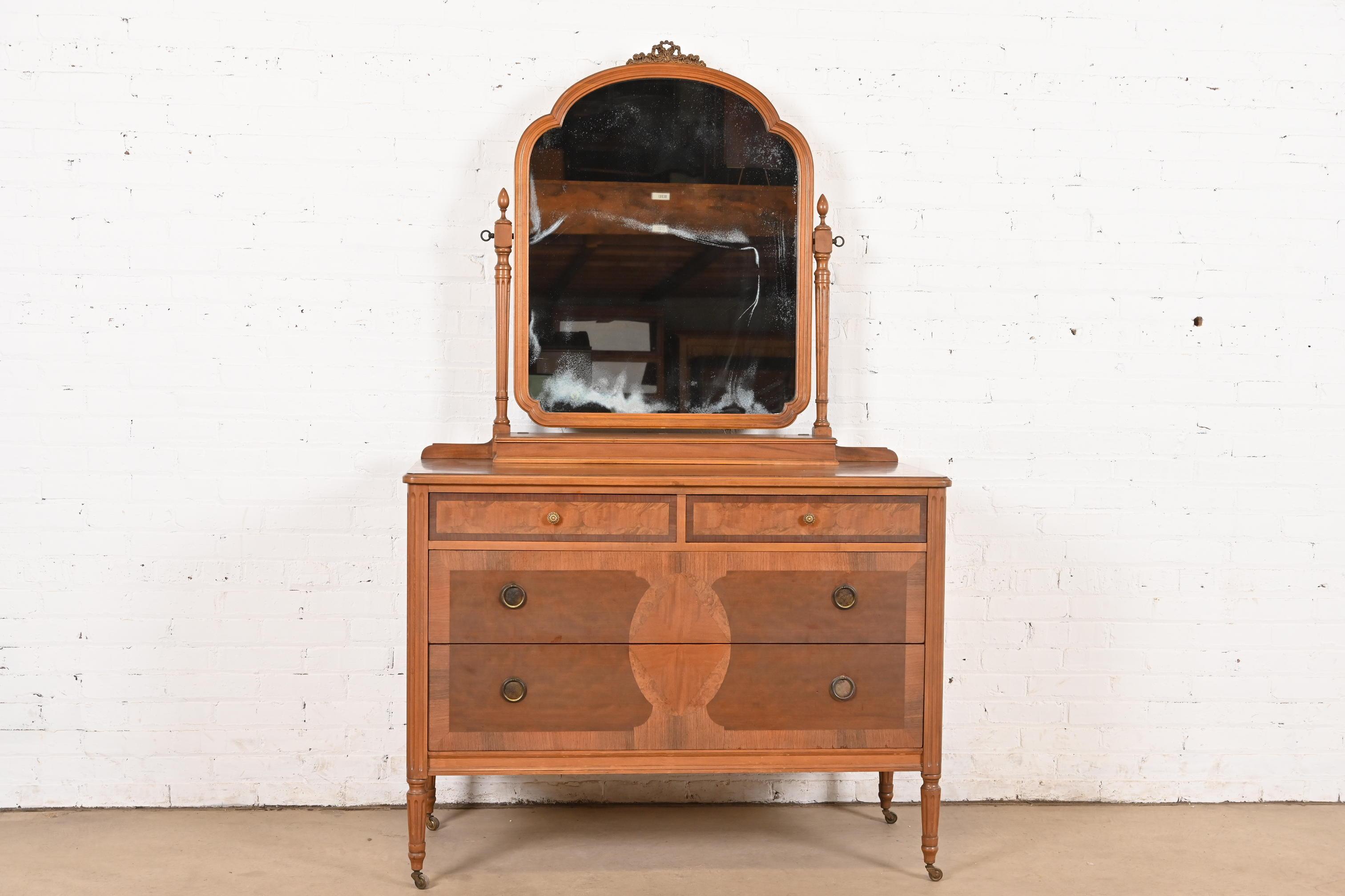 A gorgeous French Regency Louis XVI style vanity dresser with mirror

By Phoenix Furniture Co.

Grand Rapids, MI, USA, Circa 1900

Carved walnut, with inlaid burled walnut, and original brass hardware.

Measures: 46