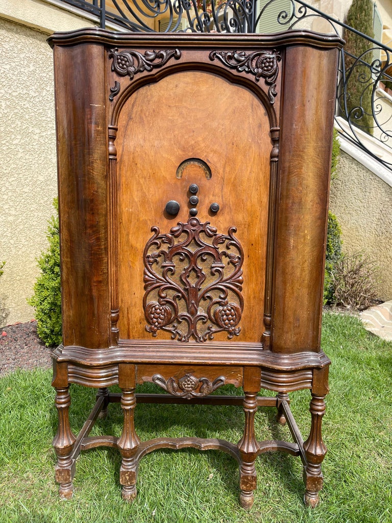 Music or phonograph cabinet making radio and record player. It is made of veneer and nicely carved.