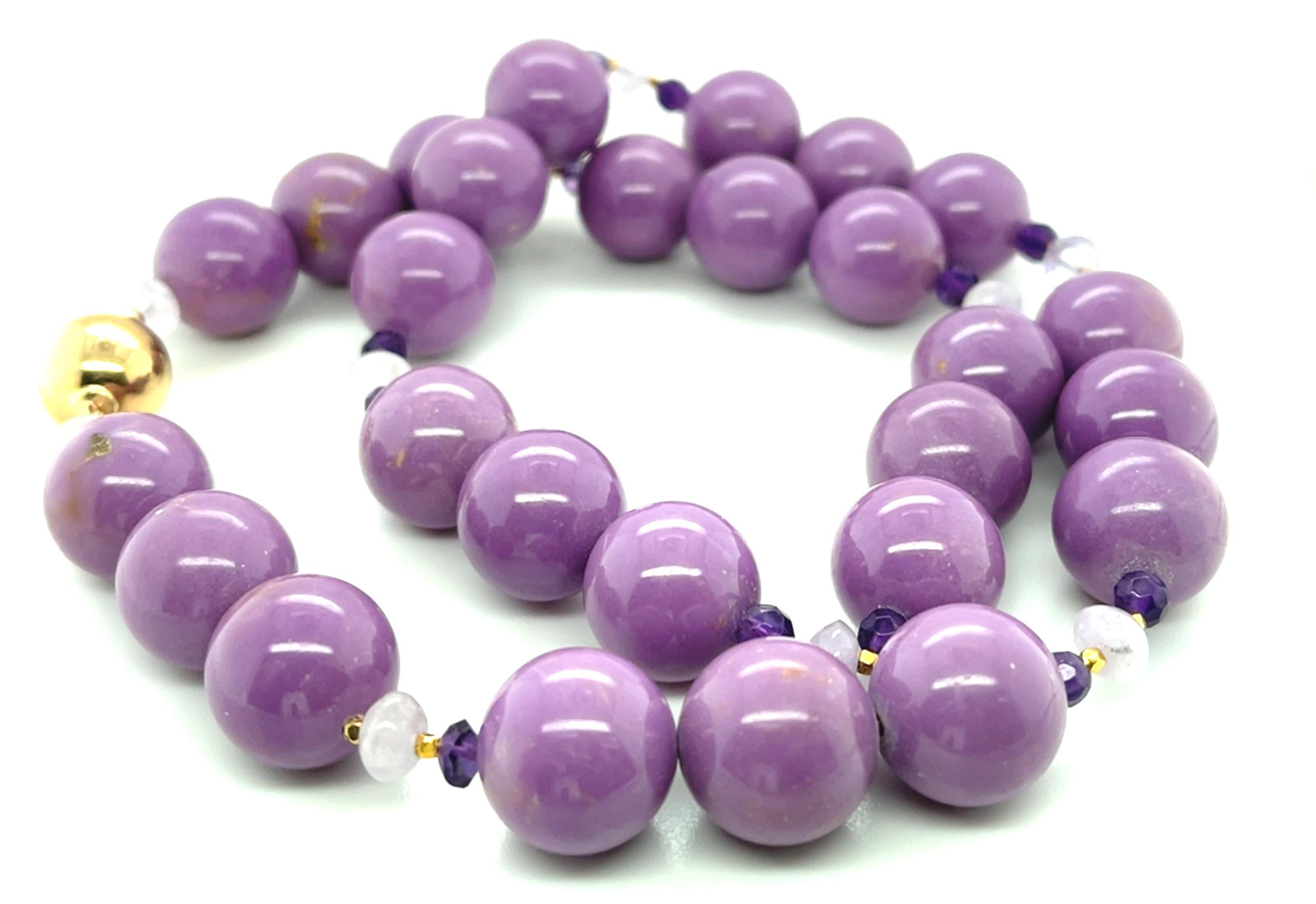 Questa collana unica presenta una collezione di rare perle rotonde di fosfosiderite da 14 mm con uno splendido colore viola vinaccia. Le perle di fosfosiderite, uniformi e perfettamente abbinate, si abbinano magnificamente all'ametista sfaccettata