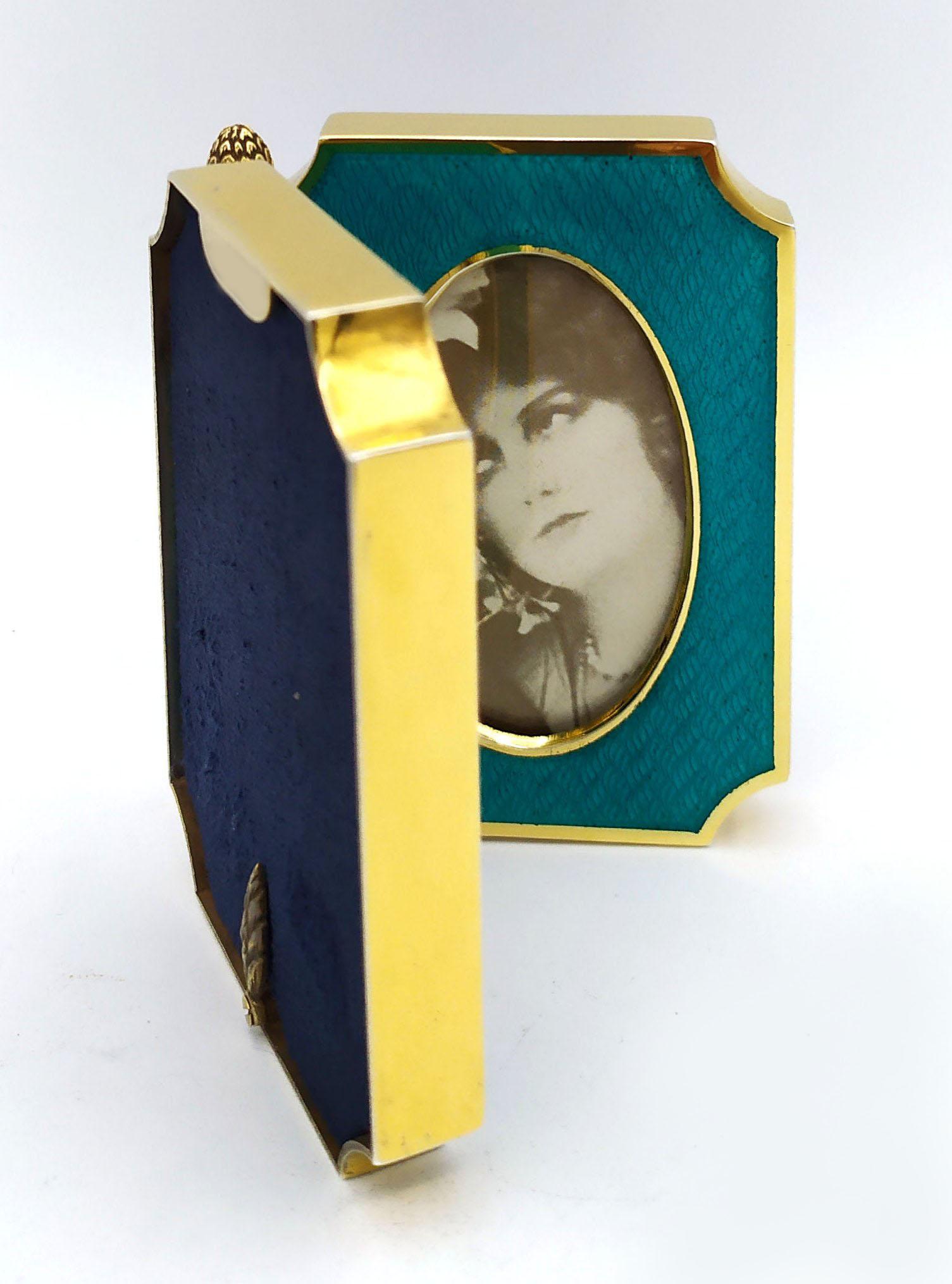 Shaped double opening photo frame in 925/1000 sterling silver gold plated with translucent fired enamel on guillochè. Early 1900s English Art Nouveau style. Open size cm. 13.5 cm high. 9.2. weight gr. 163. Designed by Giorgio Salimbeni in 1980 and