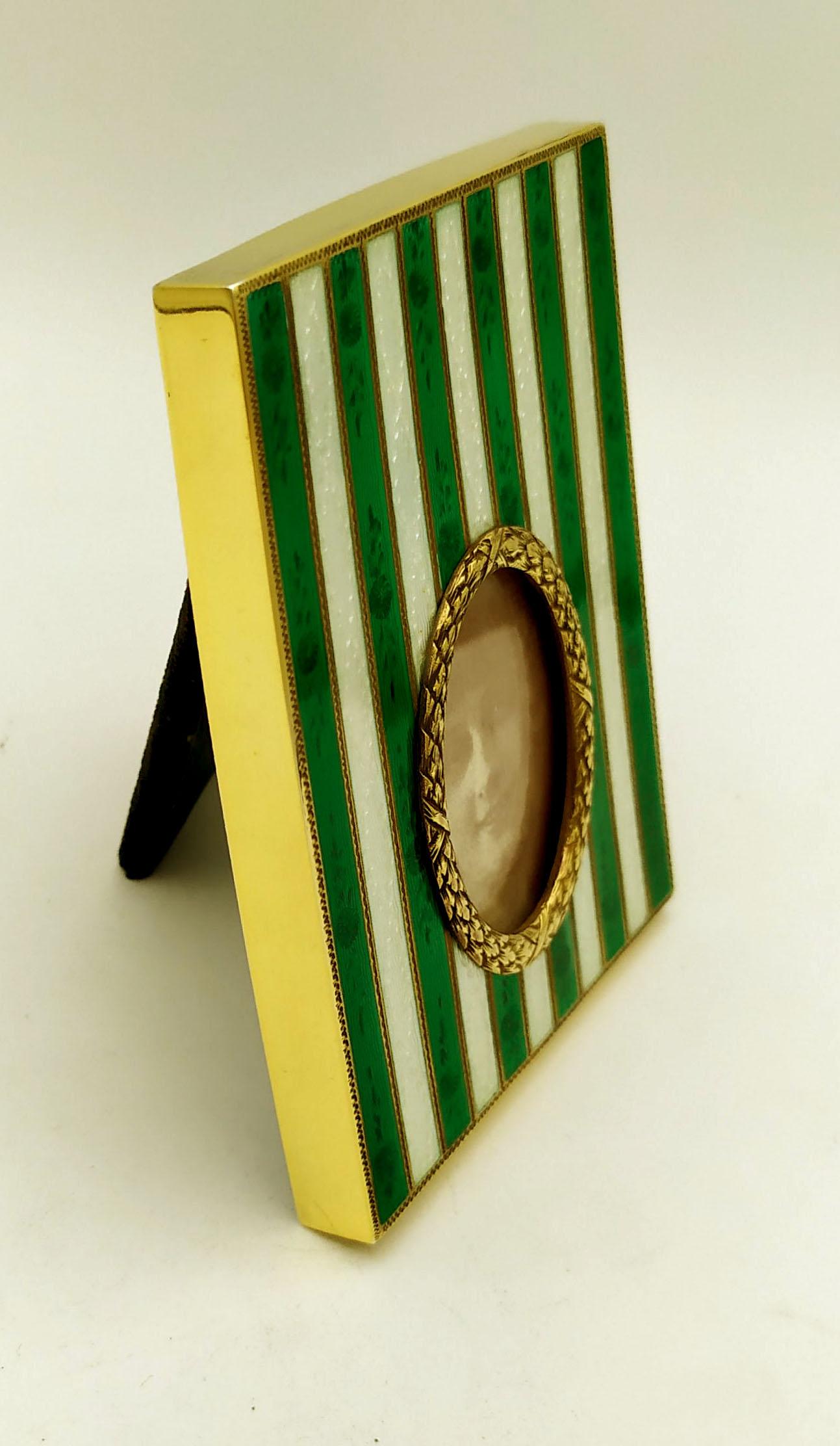 Rectangular frame with oval photo in 925/1000 sterling silver gold plated with translucent fired enamel with two-tone stripes on guillochè and hand engravings. External dimensions cm. 8 x 10 internal oval cm. 3.2 x 4.2. Weight gr. 126. Napoleon III