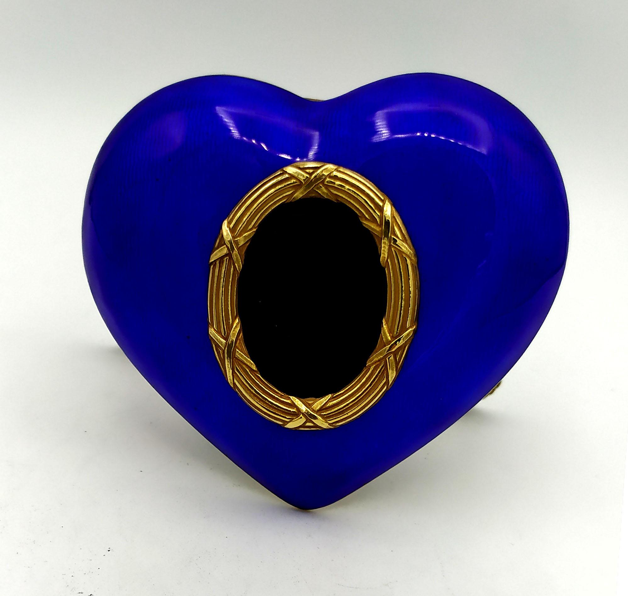 Heart-shaped rounded frame with oval photo in 925/1000 sterling silver gold plated with translucent fired enamel on guillochè. With hinged silver-gilt foot engraved in Empire style. External dimensions cm. 8.8 x 9.7 internal oval cm. 2.7 x 3.6.