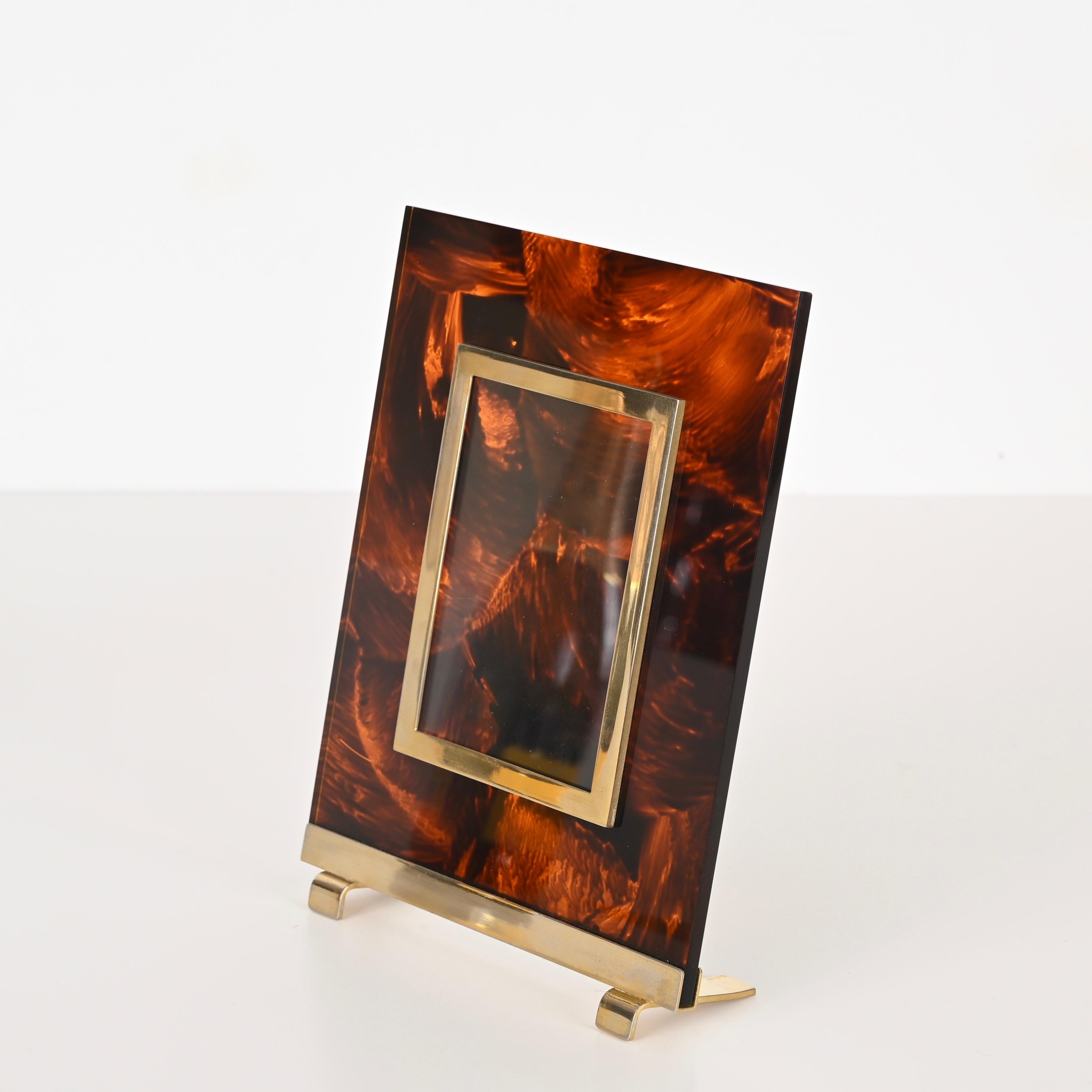 Stunning Mid-Century photo frame in tortoiseshell effect lucite and brass. This charming piece was made in Italy during the 1970s and is attributed to a Christian Dior production.

The body of this delightful photo frame is made in lucite with a