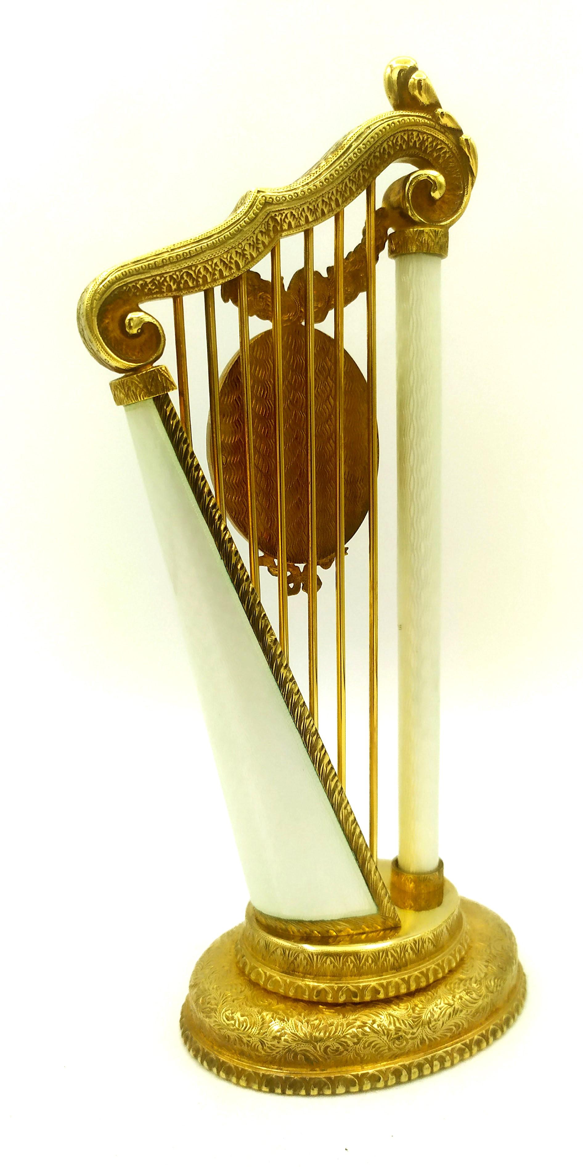 Cadre photo ovale inséré dans un objet en forme de harpe, en argent 925/1000 plaqué or avec émaux cuits translucides sur guilloché inspiré d'un modèle créé par Peters Carl Fabergè dans le style de la fin de l'Empire russe. Dimensions : base ovale