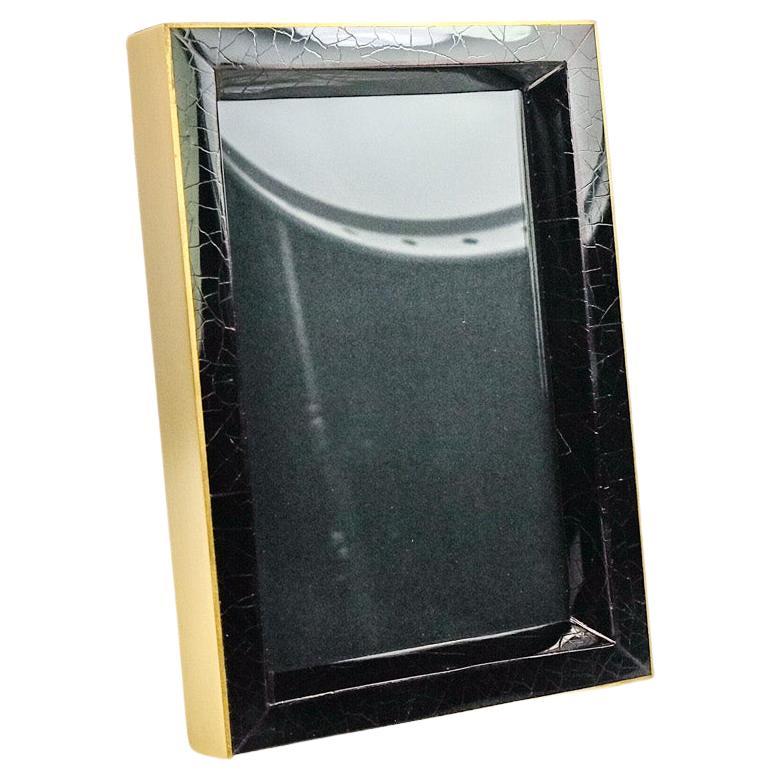 Cadre photo en marqueterie de coquillages noirs et laiton.

Dos et intérieur doublés d'un microsuède noir de haute qualité.

Pour une photo de 5x7