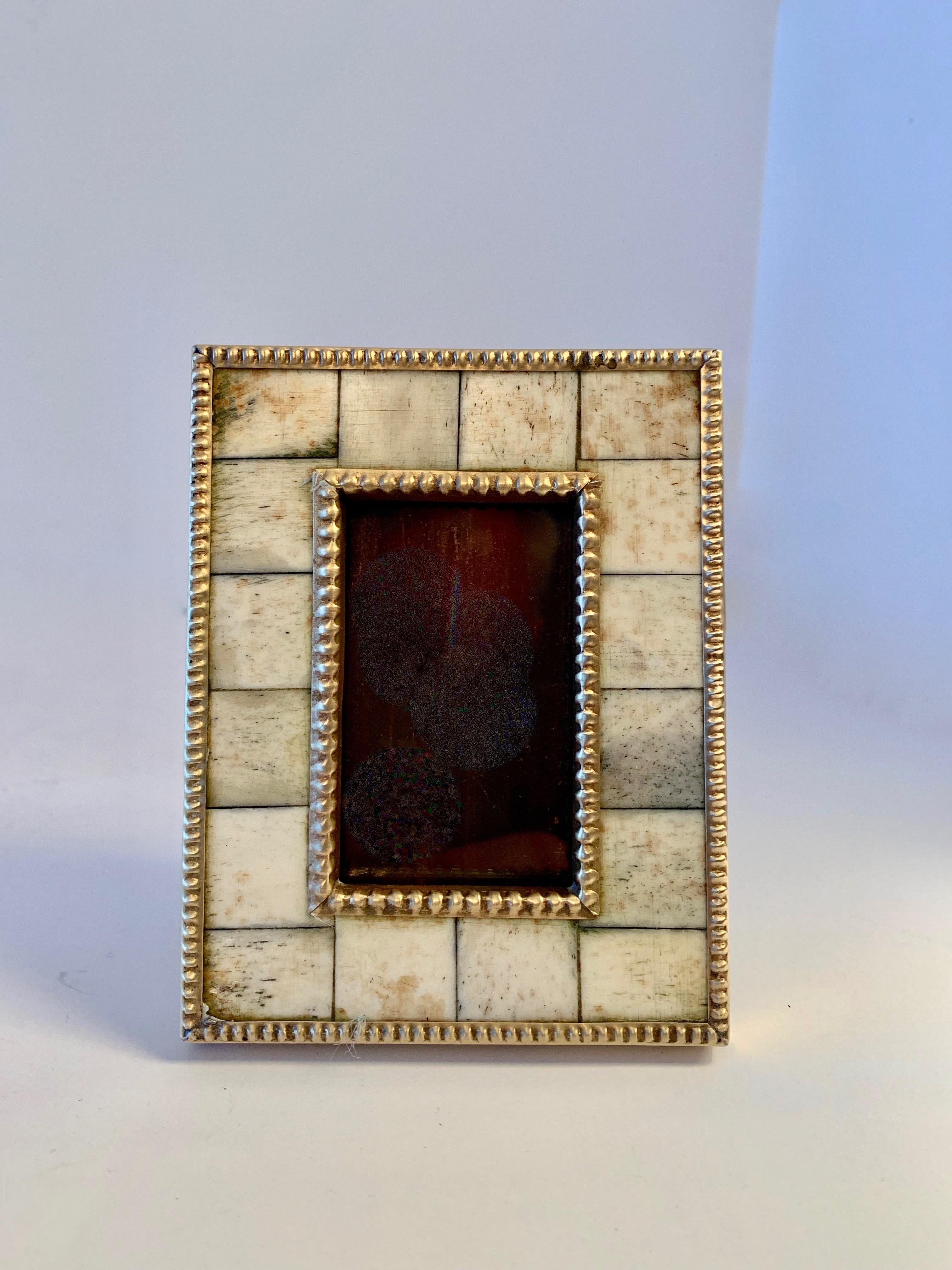 Photo frame of cut bone trimmed in pebbled brass
Image area is 1.5 x 2.5.