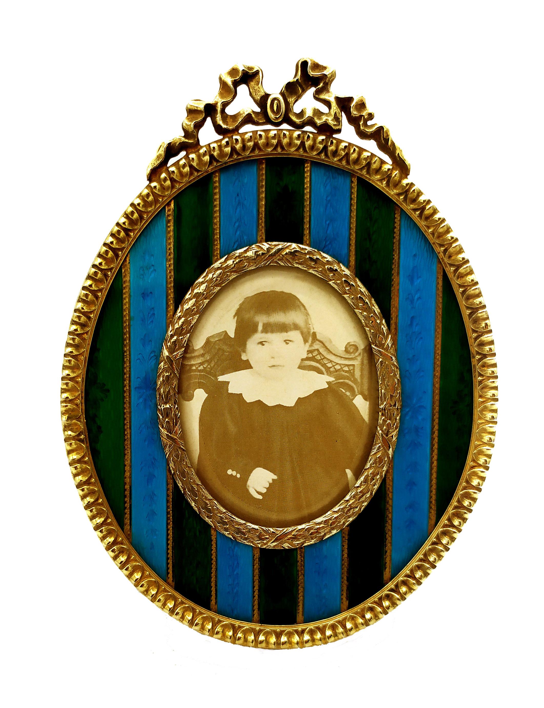 Oval frame  in 925/1000 sterling silver gold plated with two-color translucent strips fire-enameled on guillochè and hand-engraving and with French Empire Napoleon III style ornaments. Outer measure cm. 8.8 x 12 inner cm. 4 x 5.3. Weight gr. 125.