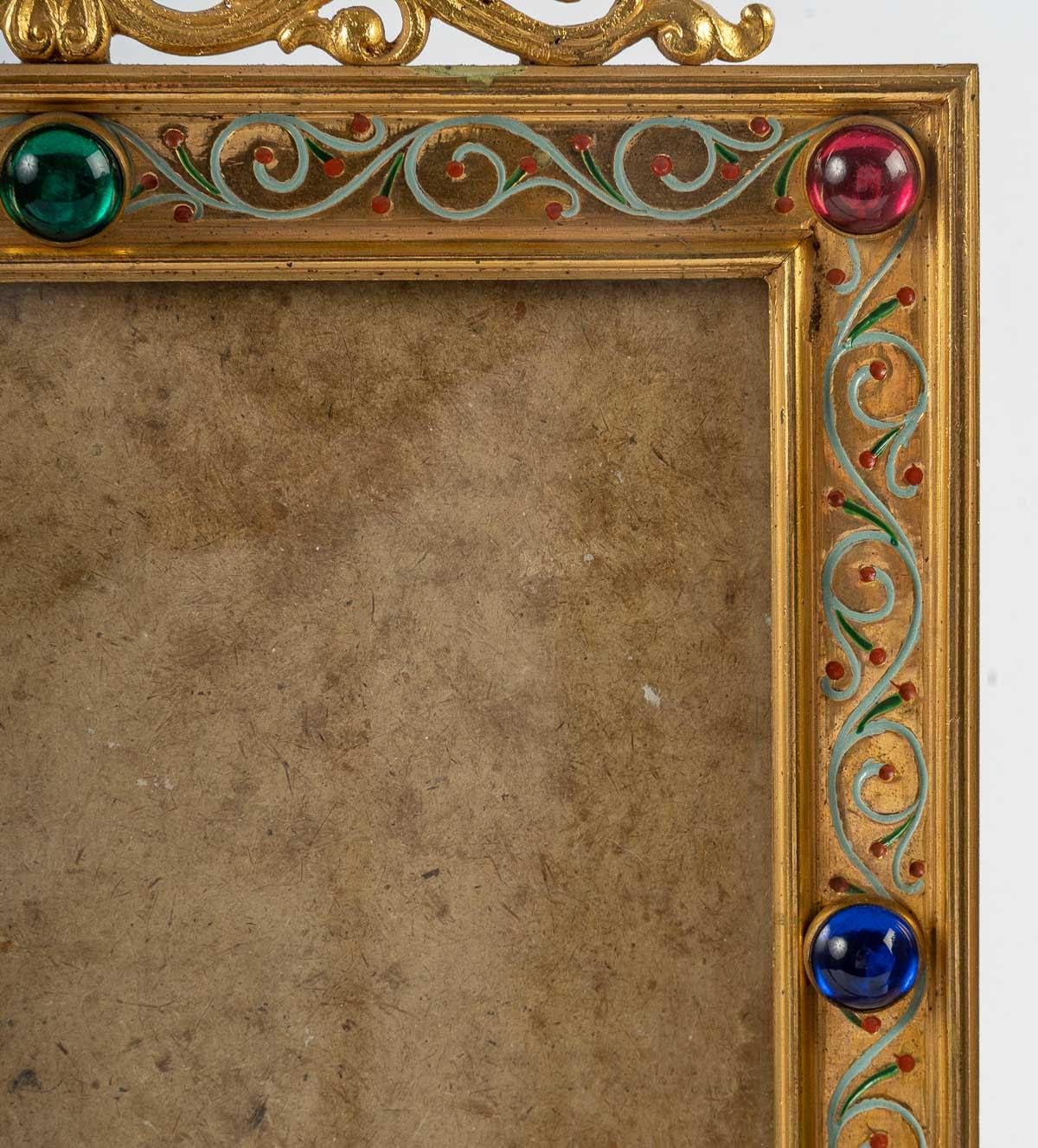 Photo frames, gilt bronze with coloured glass cabochons, 19th century, Napoleon III period, on bronze castors on the base.
The large one - H: 41.3 cm, W: 48 cm, L: 8 cm.