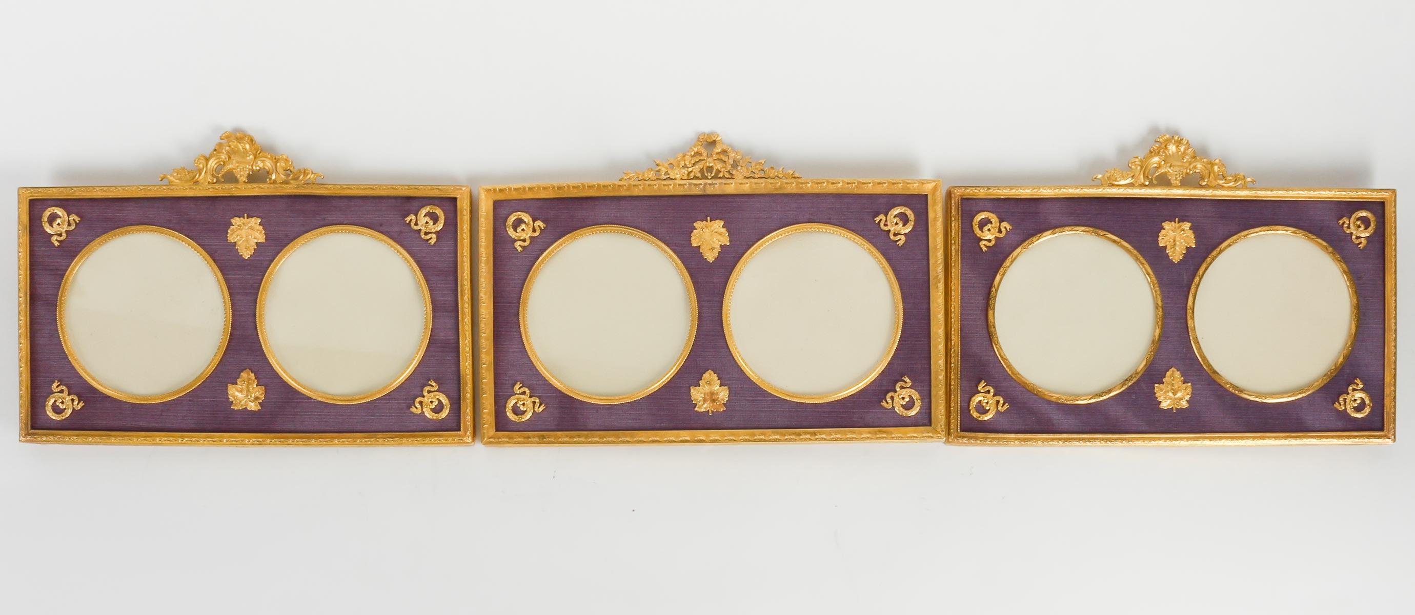 Suite of 3 Photo Frames for 2 Photos each in Gilt Bronze and Fabric, 19th Century, Louis XVI Style.

Suite of 3 Photo Frames for two photos each in the Louis XVI style, gilt bronze and violet fabric, 19th century, Napoleon III period.
H: 18cm, W: