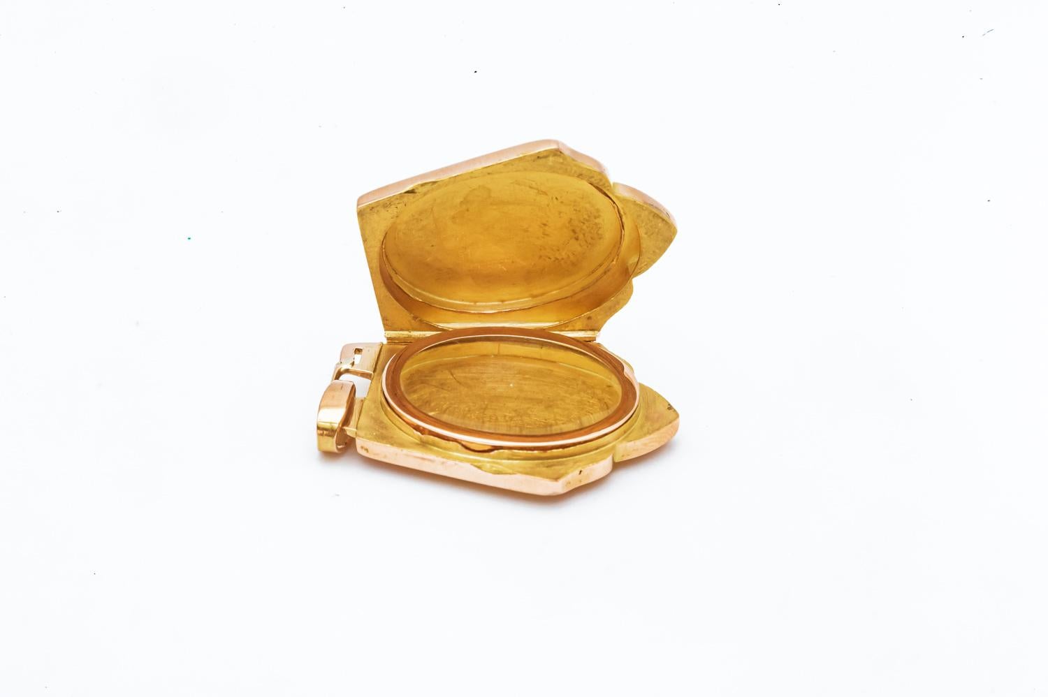 Découvrez ce magnifique pendentif porte-photo d'époque Napoléon III, un bijou d'une rare beauté et d'une grande valeur historique. Réalisé en or rose 18 carats, ce pendentif en forme de bouclier est un véritable trésor d'antan.

La face avant du