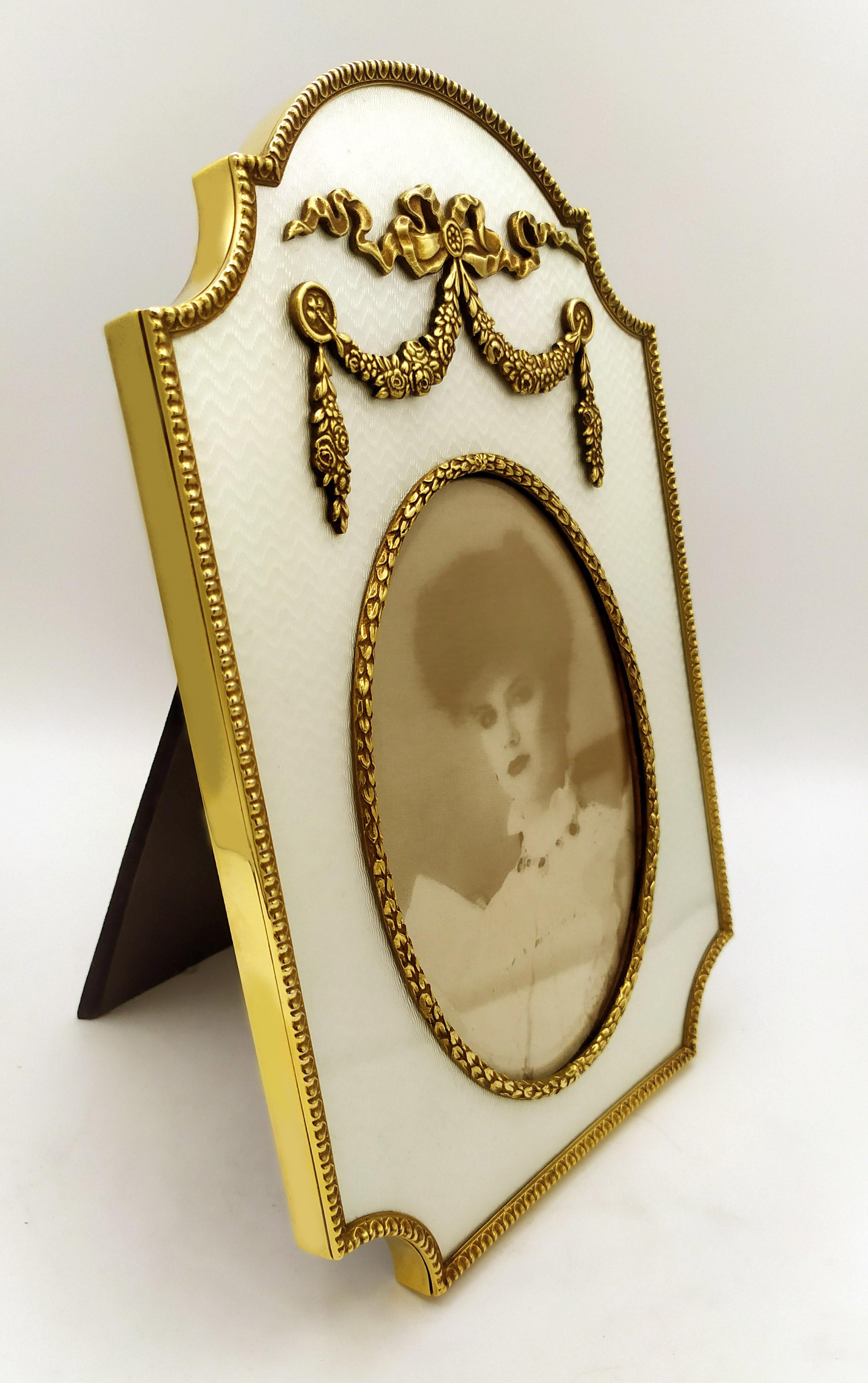 Large gold-plated 925/1000 sterling silver shaped photograph frame with translucent fired enamel on guillochè and rich friezes in Louis XVI French Empire style. External measurements cm. 18 x 27, internal oval cm. 11 x 15. Silver weight gr. 678.