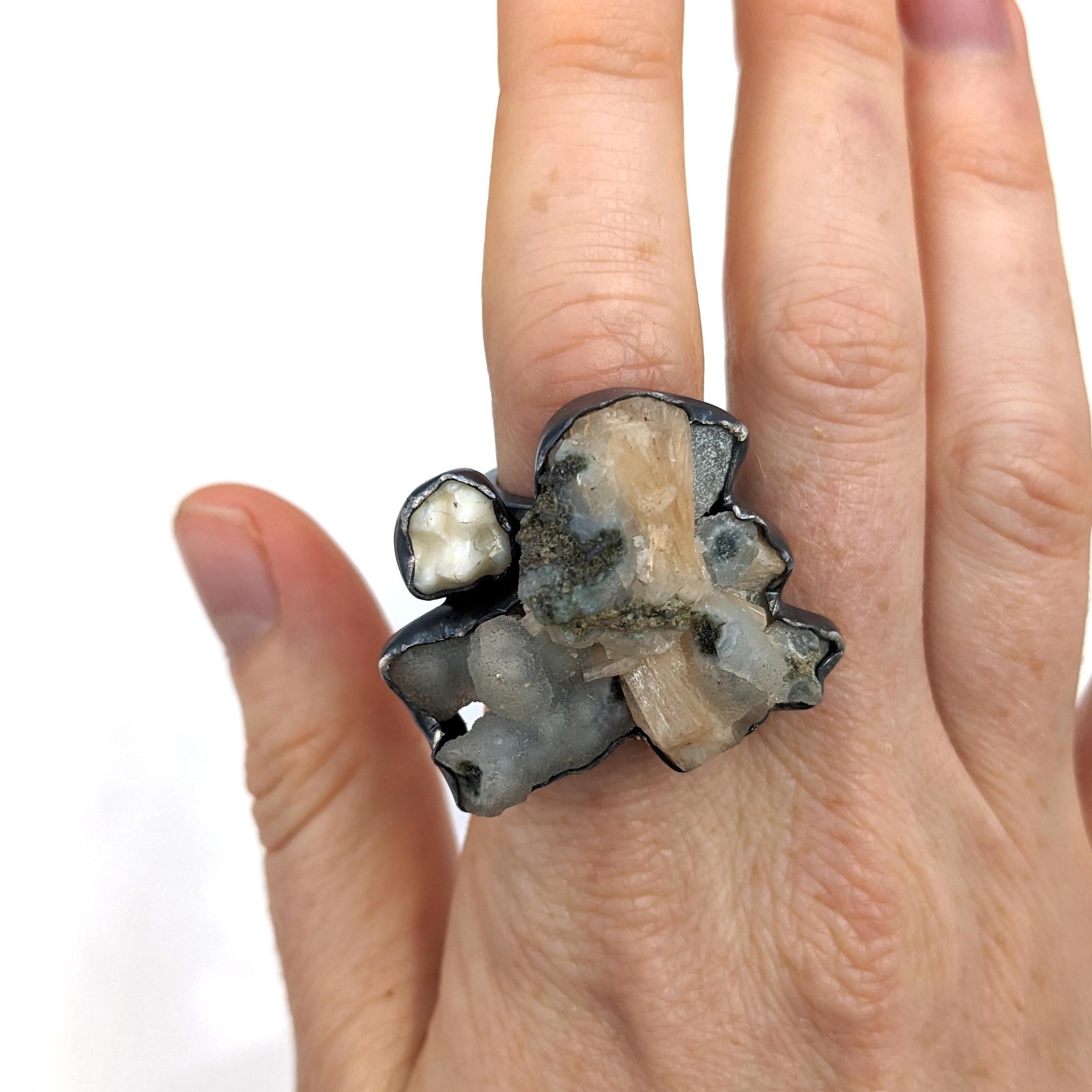 The Phyla-Roda ring features Apophylite, Silbite, a raccoon tooth, and silver. The top face of the ring measures approximately 1.25