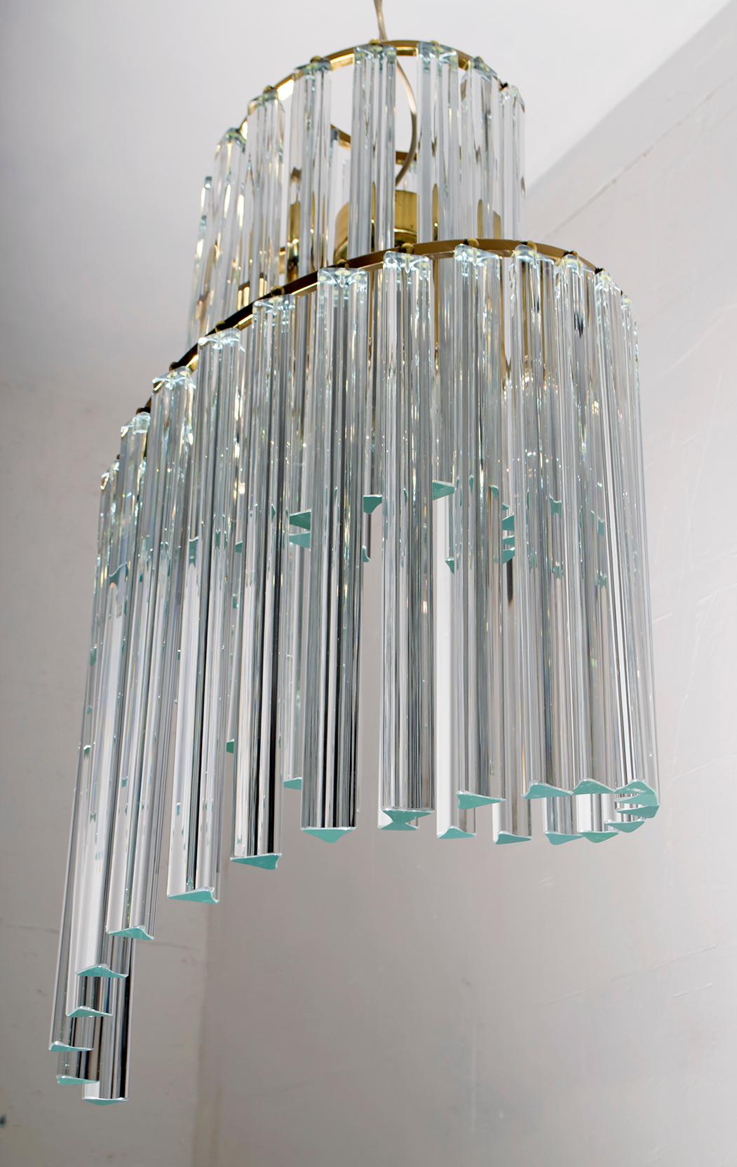 This chandelier was designed by the famous Italian designer Pia Guidetti Crippa for the Lumi Milano company, is composed of 41 Murried glass Triedri with a length of 41 cm, was produced in the 1970s, has a spiral shape and a structure in golden