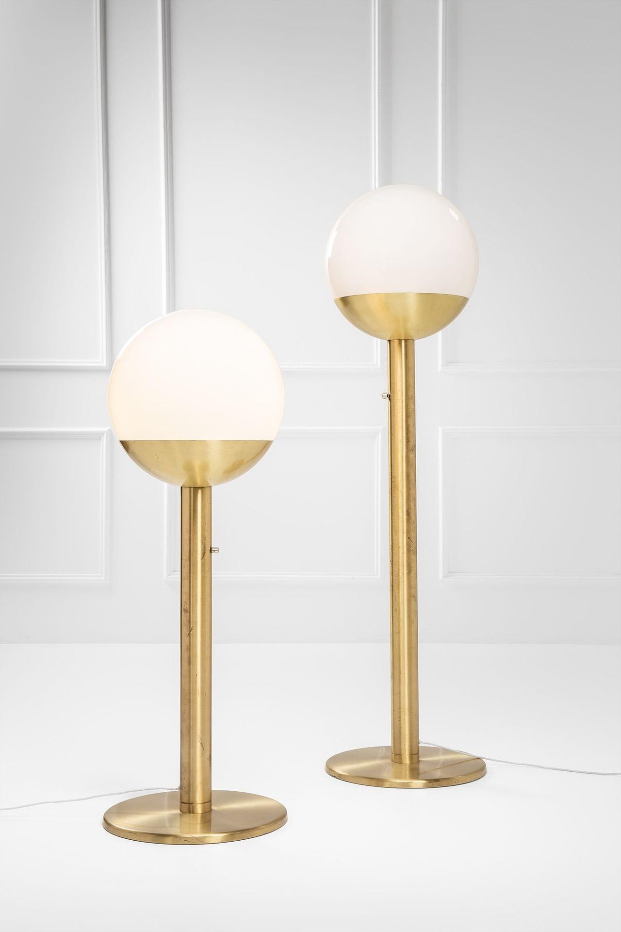 Elegantes Paar P428 Stehlampen, entworfen von Pia Guidetti Crippa für einen italienischen Leuchtenhersteller, um 1970.
Jede Leuchte verfügt über eine elegante, vermessingte Metallstruktur, die von einer weißen Opalglas-Kugel gekrönt wird, die ein