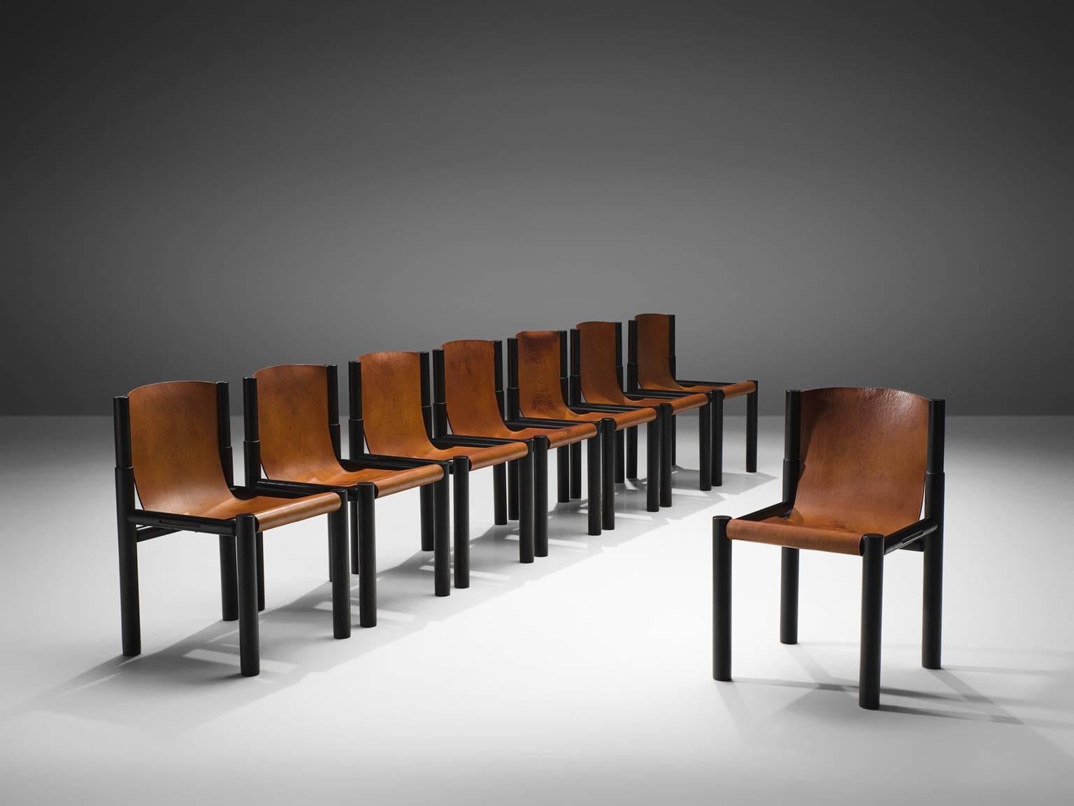 Pia Manu, dining chairs, cognac leather, ebonized wood, Belgium, 1970s 

These robust chairs feature a geometric, sturdy black painted wooden frame. They are executed with fine cognac leather that has patinated over time. The leather of the seat