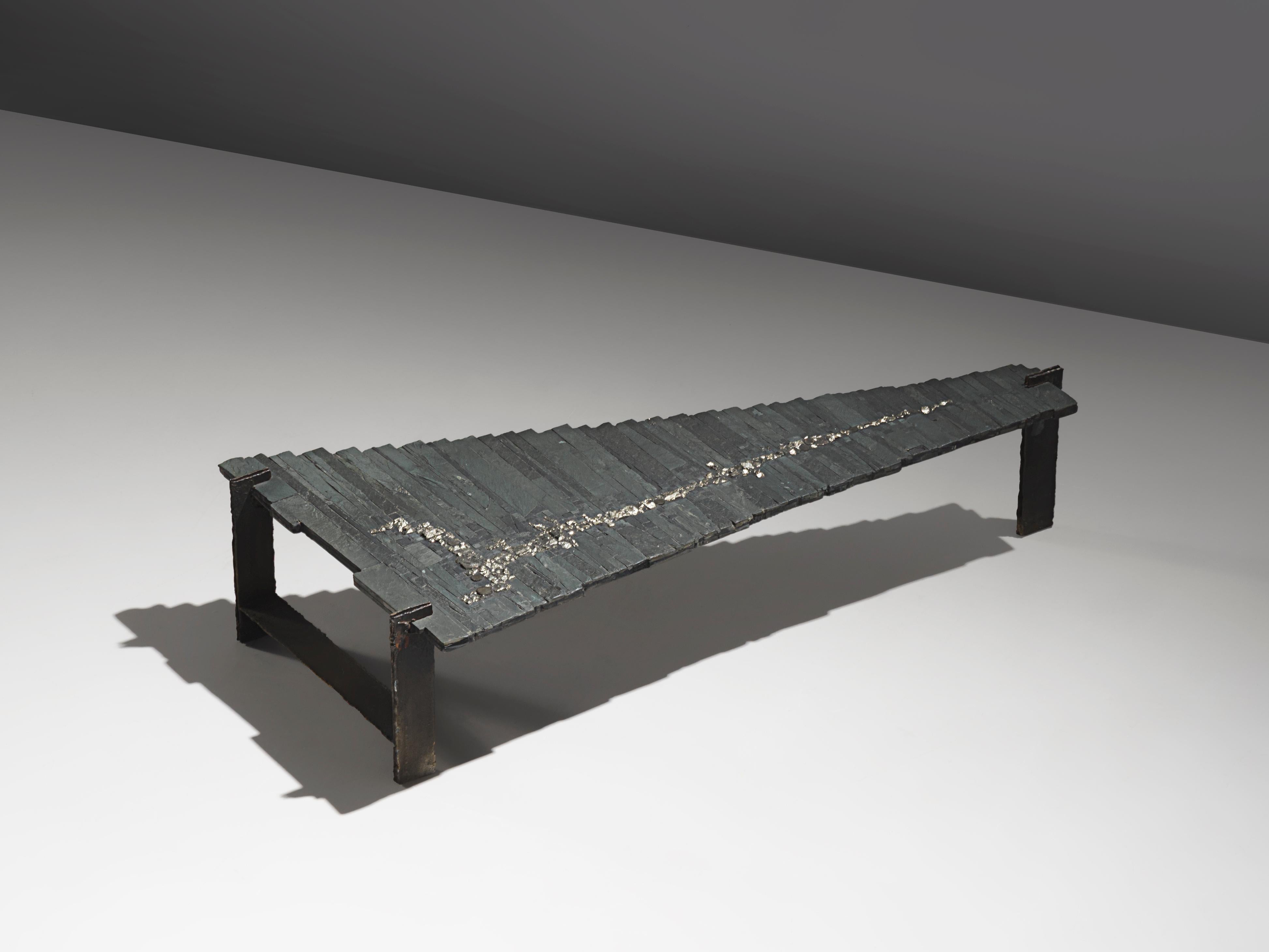 Pia Manu, coffee table, slate, iron and pyrite Belgium, 1970s.

One of a kind brutalist cocktail table by Pia Manu. The table top consists of long pieces of slate in differnet lengths, positioned in a row. The top is inlayed with an abstract