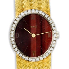 Piaget 18 Karat Gelbgold Tigerauge-Zifferblatt und Diamant-Halo-Uhr, 6,25-6,5"