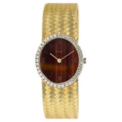 Piaget 18 Karat Gelbgold Tigerauge-Zifferblatt und Diamant-Halo-Uhr, 6,25-6,5"
