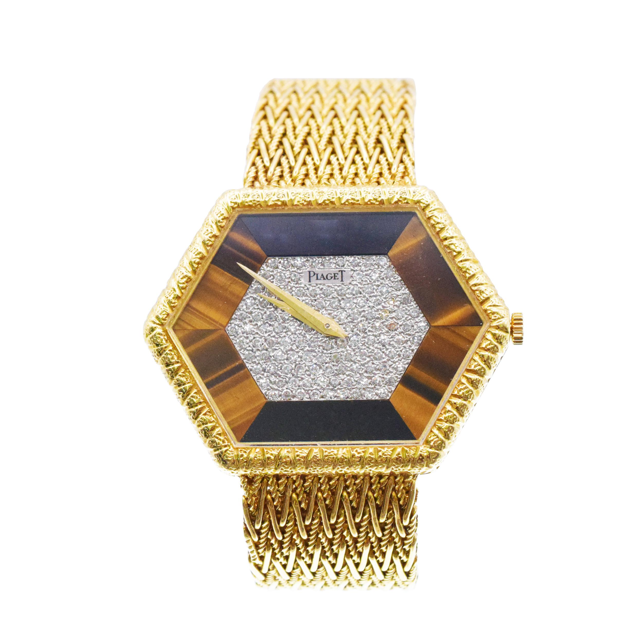 Piaget 18k yellow gold hexagon wrist watch with diamond and tiger eye accents. Circa
1970's. The watch features hexagon shaped case, encrusted with 122 round single cut diamonds with weightof approximately 0.60ct, surrounded by halo of Tigers Eye