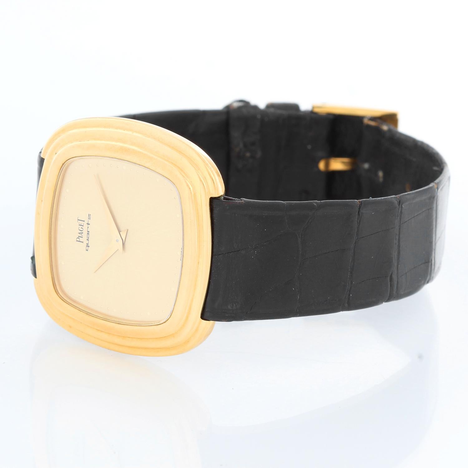 Piaget 18K Yellow Gold Men's Quartz Watch - Quartz. 18K Yellow gold ( 29 x 34 mm). Champagne dial. Black leather Piaget strap with Piaget tang buckle. Pre-owned with Piaget service case and papers. Dated 1985.