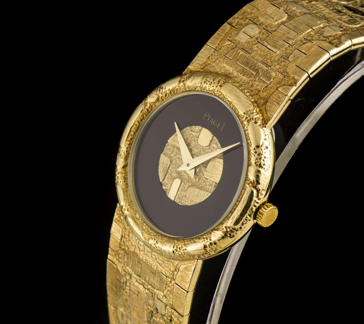 A 26 mm 18k Yellow Gold Ladies Dress Watch, onyx dial with gold insert, a fixed 18k yellow gold bezel, an 18k yellow gold integrated bracelet with an 18k yellow gold jewellery style clasp, mineral glass, manual wind movement, in excellent condition,