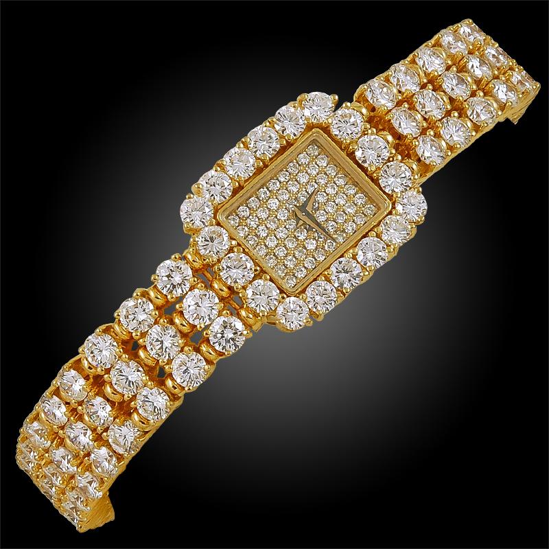 Piaget 18mm Diamond Halo Bracelet Watch in 18k Yellow Gold.
A vintage Piaget watch with diamonds on the band and dial, mounted in yellow gold. The band features flexible bracelet links comprised of white round brilliant diamonds in three rows which