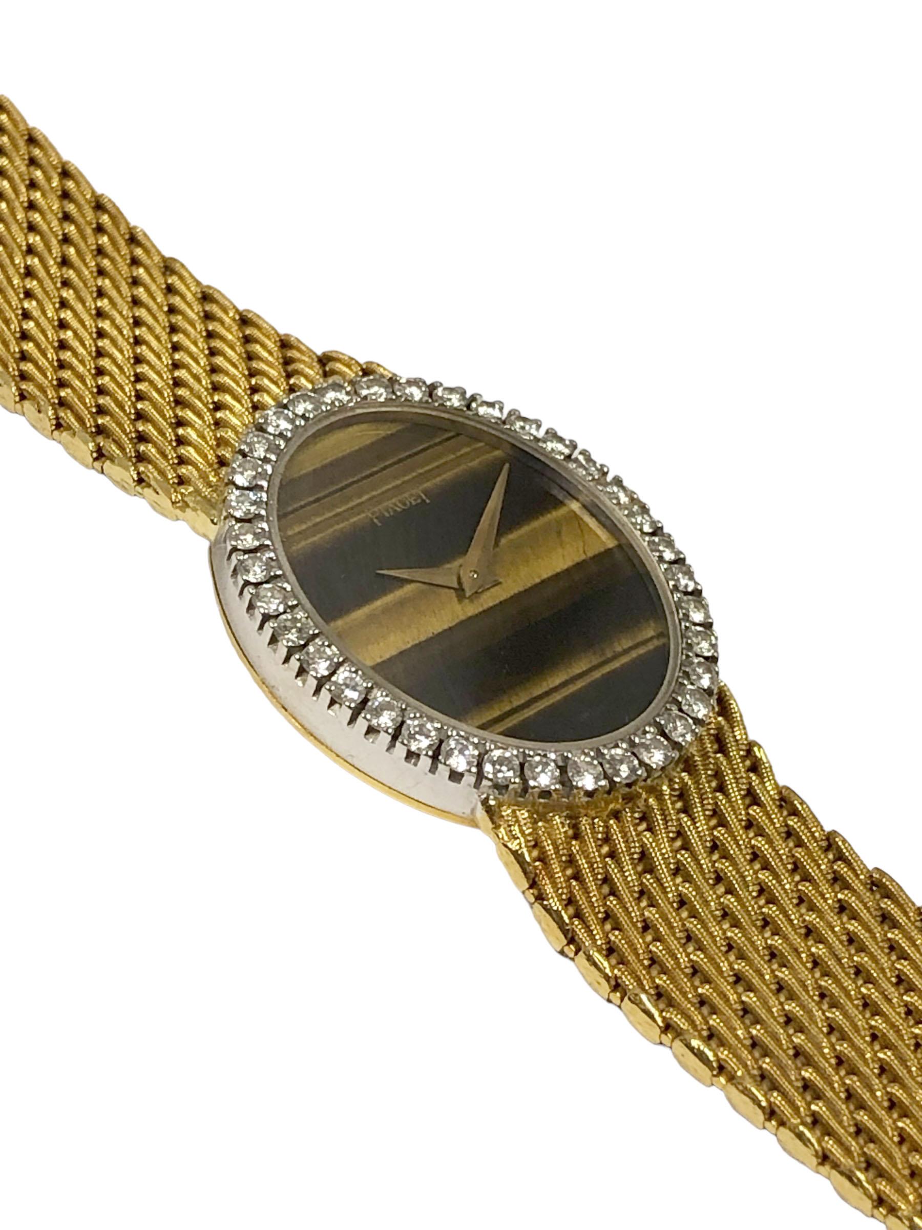 Circa 1970s Piaget Ladies Wrist Watch, 26 X 22 M.M 2 Piece 18K Yellow Gold Oval case with White Gold Bezel set with Round Brilliant cut Diamonds totaling 1 carat. 17 Jewel, Mechanical, Manual wind Movement. Tigers Eye Stone Dial, Piaget 5/8 inch