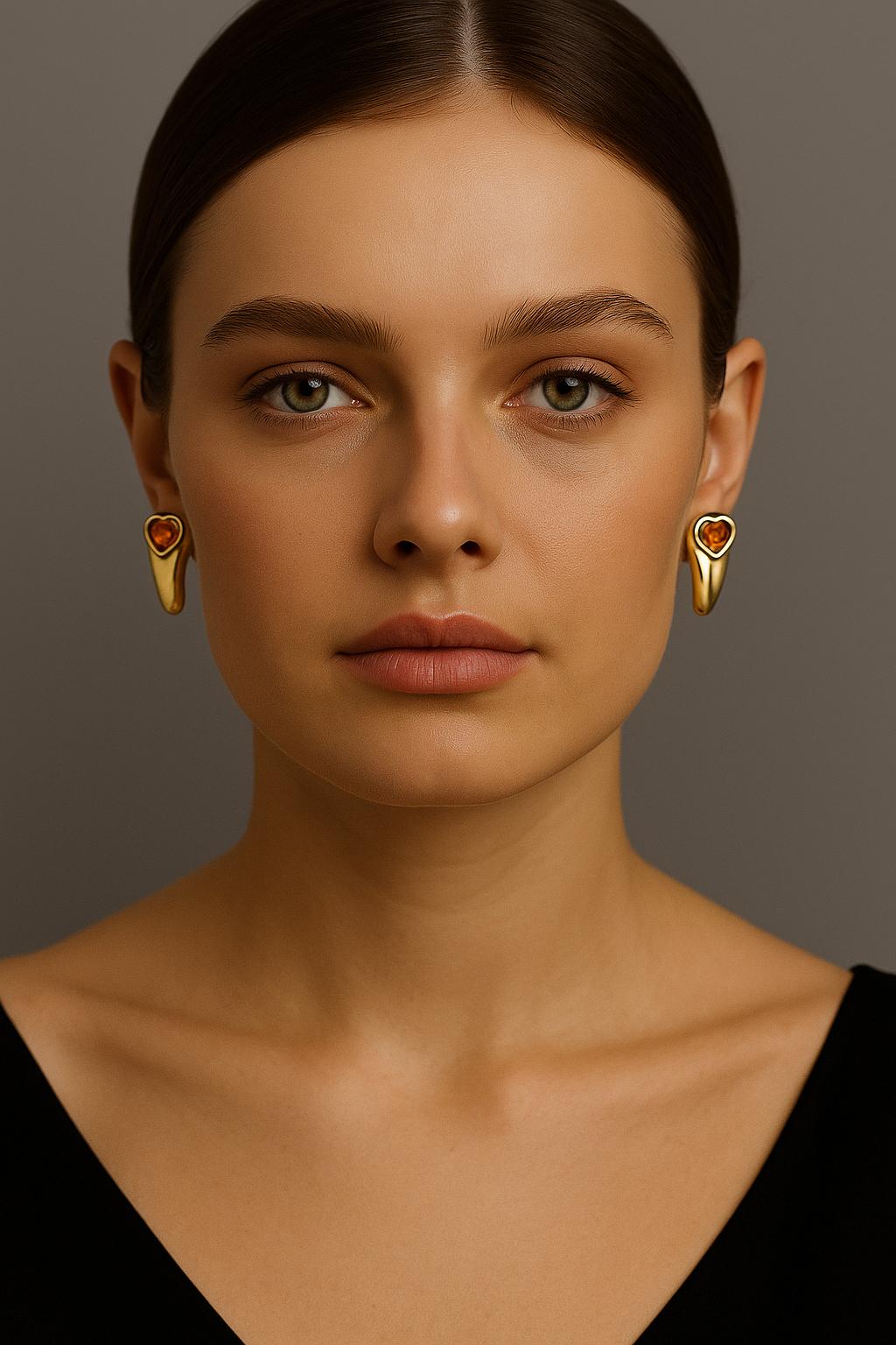 A refined and collectible pair of earrings by Piaget, crafted in 750 / 18K yellow gold. Each earring features a richly coloured, heart-shaped citrine—estimated at approximately 2.35 to 2.50 carats per stone—securely bezel-set within a bold,