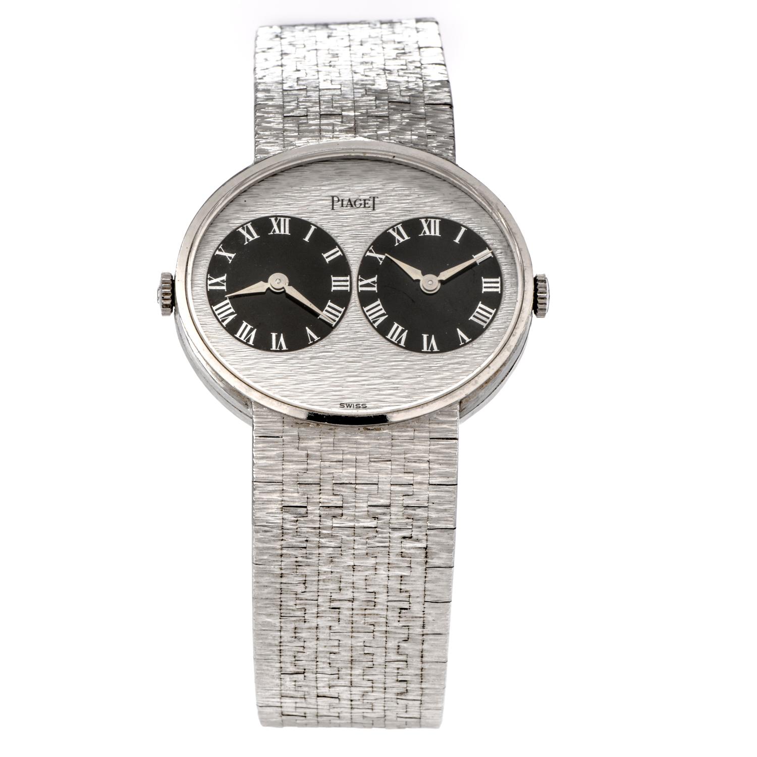 Admire this unique Vintage Piaget 18K White Gold two zone Textured Watch! 

This collectable 1970's  watch is crafted in 18 karat textured  white gold and purity marked.

The over sized  watch with oval case is  featuring two black dial clocks side