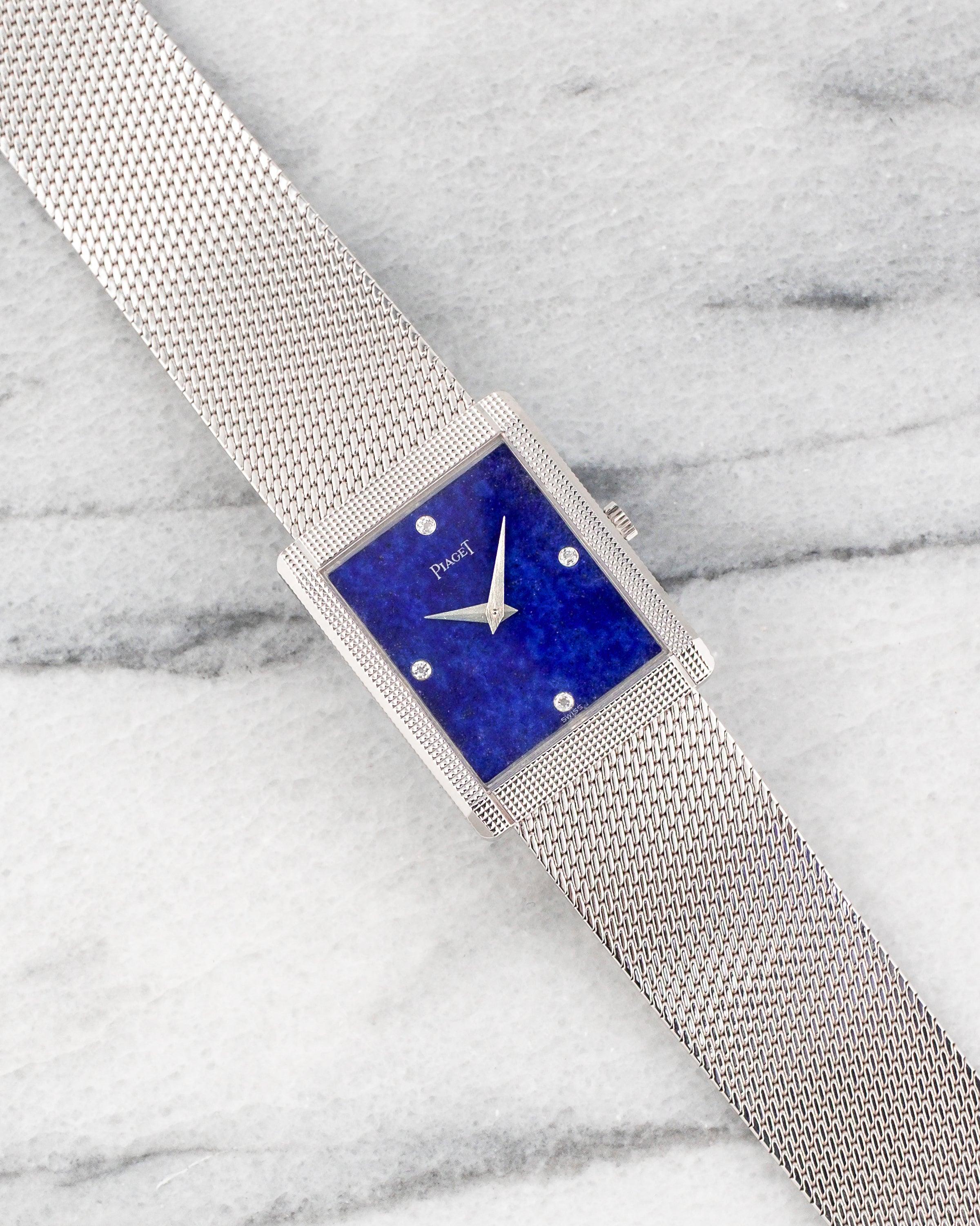 Here's a vintage Piaget reference 9151 manual wind in 18k white gold with a blue lapis stone dial on a white gold mesh bracelet from the 1970s. Keeps great time and is fully functional. Measurements include a 25mm rectangular white gold case. It's