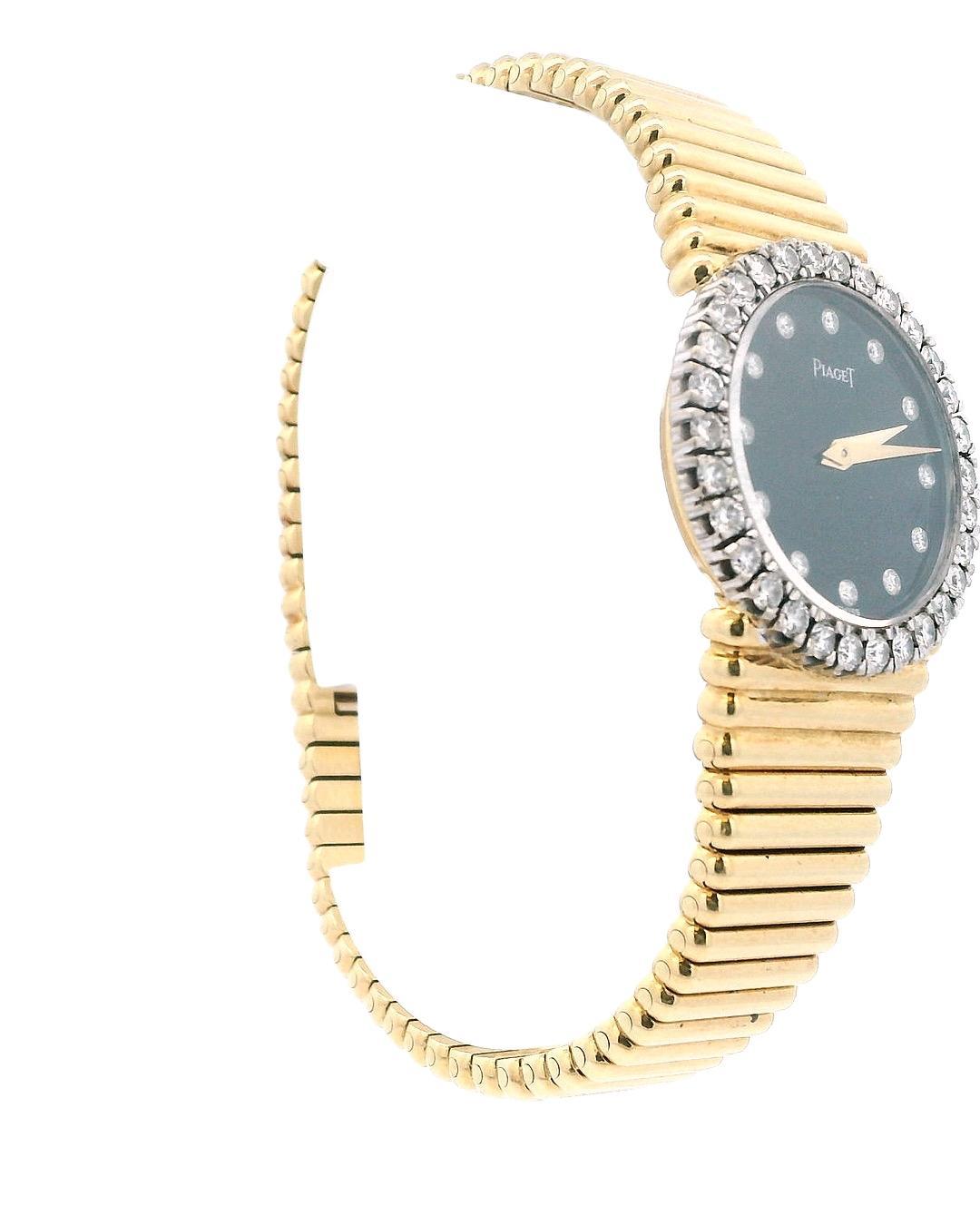 This elegant Piaget watch is crafted in 18k yellow gold. It features a round black dial adorned with diamond hour markers and a diamond-set bezel.

The watch is powered by a manual movement.

The watch face measures 26 mm in diameter.

Total weight