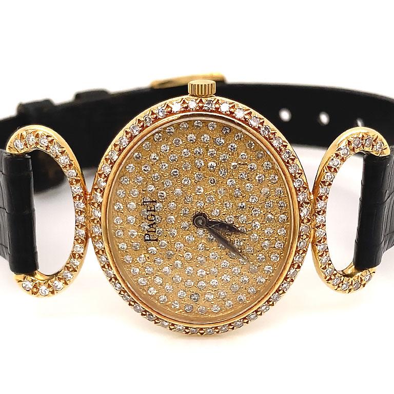 Piaget Classique 18K Yellow Gold Diamond Vintage Ladies Watch Ref. 9802. This stunning watch features an oval 18k yellow gold case measuring 27mm x 25mm with closed solid back. The watch has a Pave' set diamond dial, bezel and lugs. The watch has a