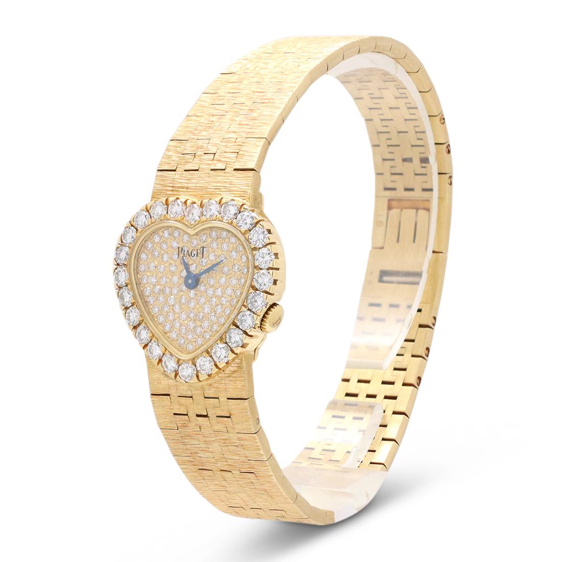 Authentic Piaget Classique Heart watch crafted in 18 karat yellow gold. The heart-shaped case measures 21mm x 20mm with a pave diamond dial and diamond bezel. Quartz movement. The textured gold bracelet features a fold-over clasp closure. Signed