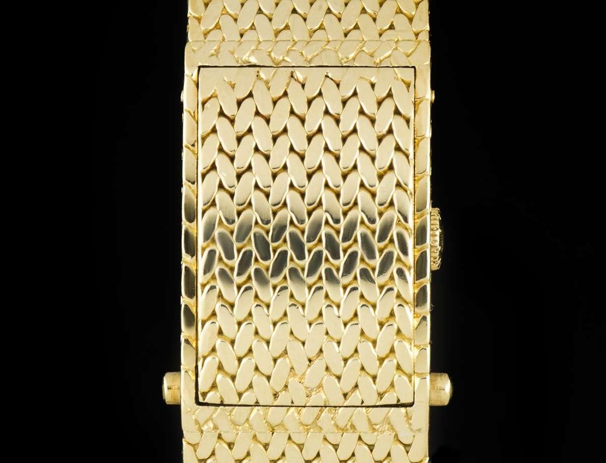 This 16 mm 18k yellow gold Concealed Case women's wristwatch, by Piaget, is powered by a manual wind movement. 

Time is displayed on a champagne dial, which is protected by a sapphire crystal and concealed behind a textured 18k yellow gold cover.