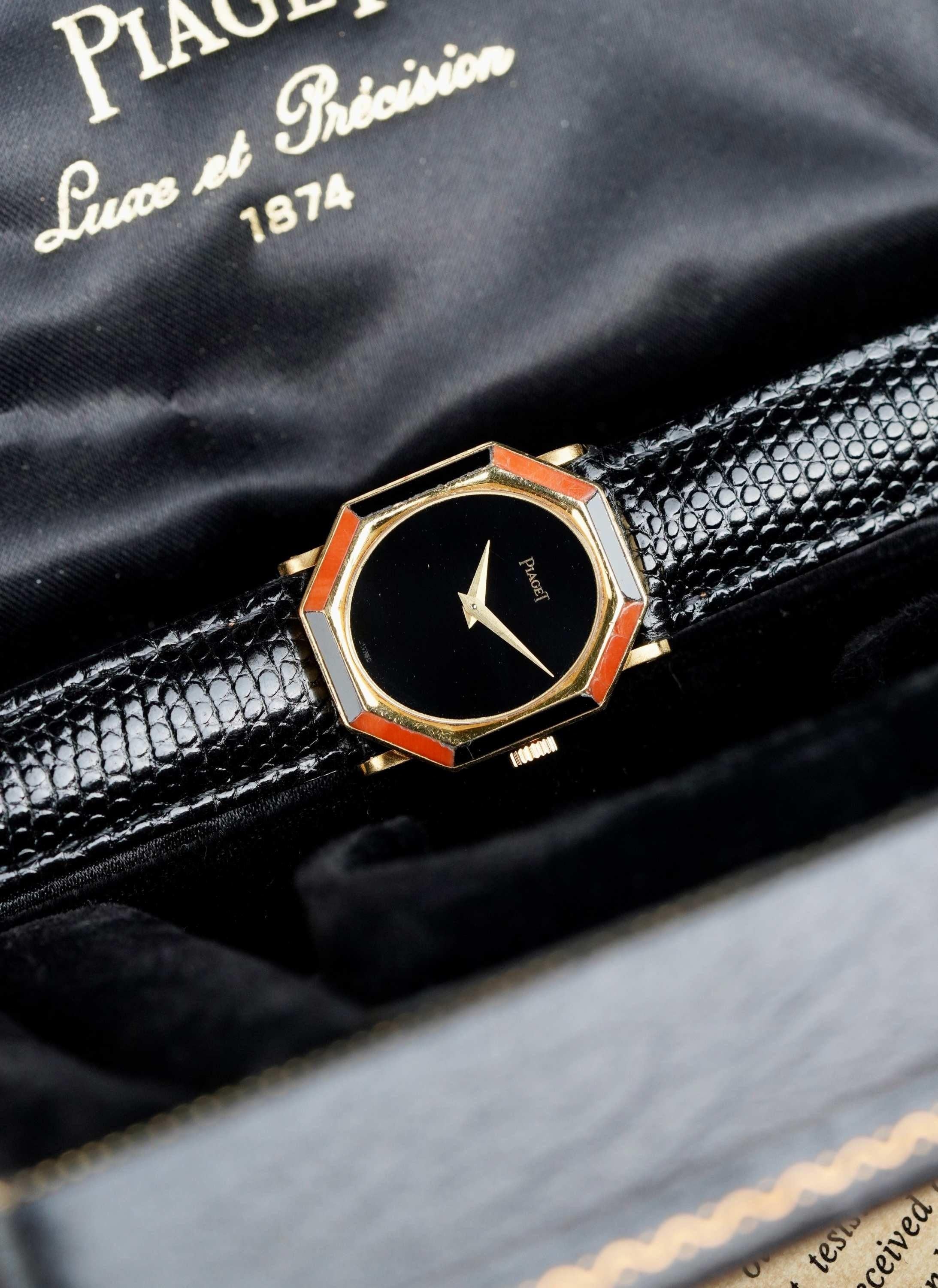 Here we have a very unique vintage full set (box and papers) Piaget manual wind reference 9341 in 18K yellow gold with an onyx stone dial and double stone bezel with 8 hand-cut coral and onyx stones as the bezel. At 1 o’clock the coral stone is