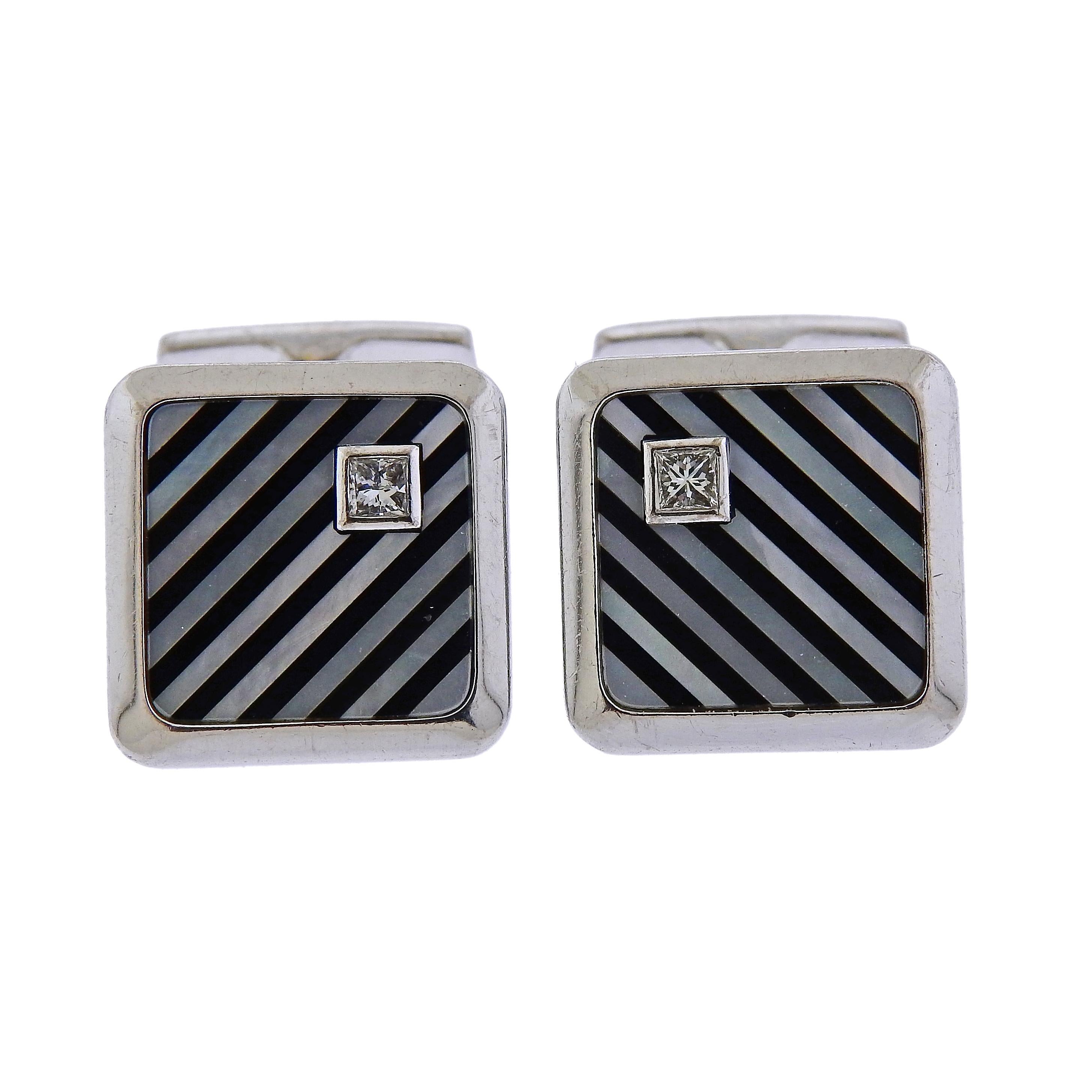 18k gold pair of cufflinks by Piaget, featuring onyx and mother of pearl inlaid stripes, as well as 0.09ctw in diamonds. Cufflink top is 16mm x 16mm, cufflinks weigh 17.5 grams. Marked A20930, 0.09, Piaget, 750.