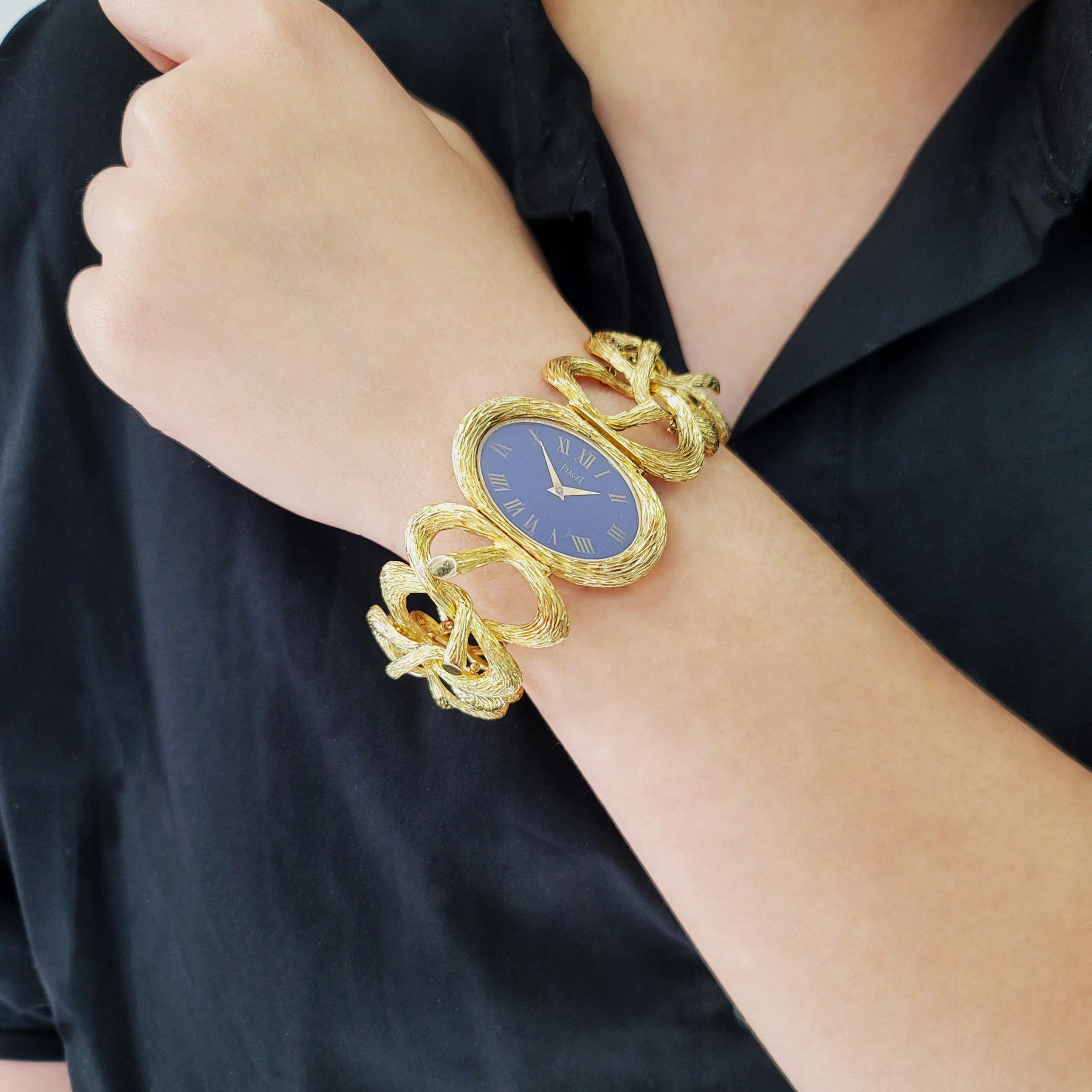 Piaget Esclave Lapis Lazuli Dial Ladies Watch In 18k yellow gold. Circa 1970's. The watch features oval case, lapis lazuli face with gold minute and hour hands, and 12 gold roman numeral markers around the dial. The watch is completed with 18k