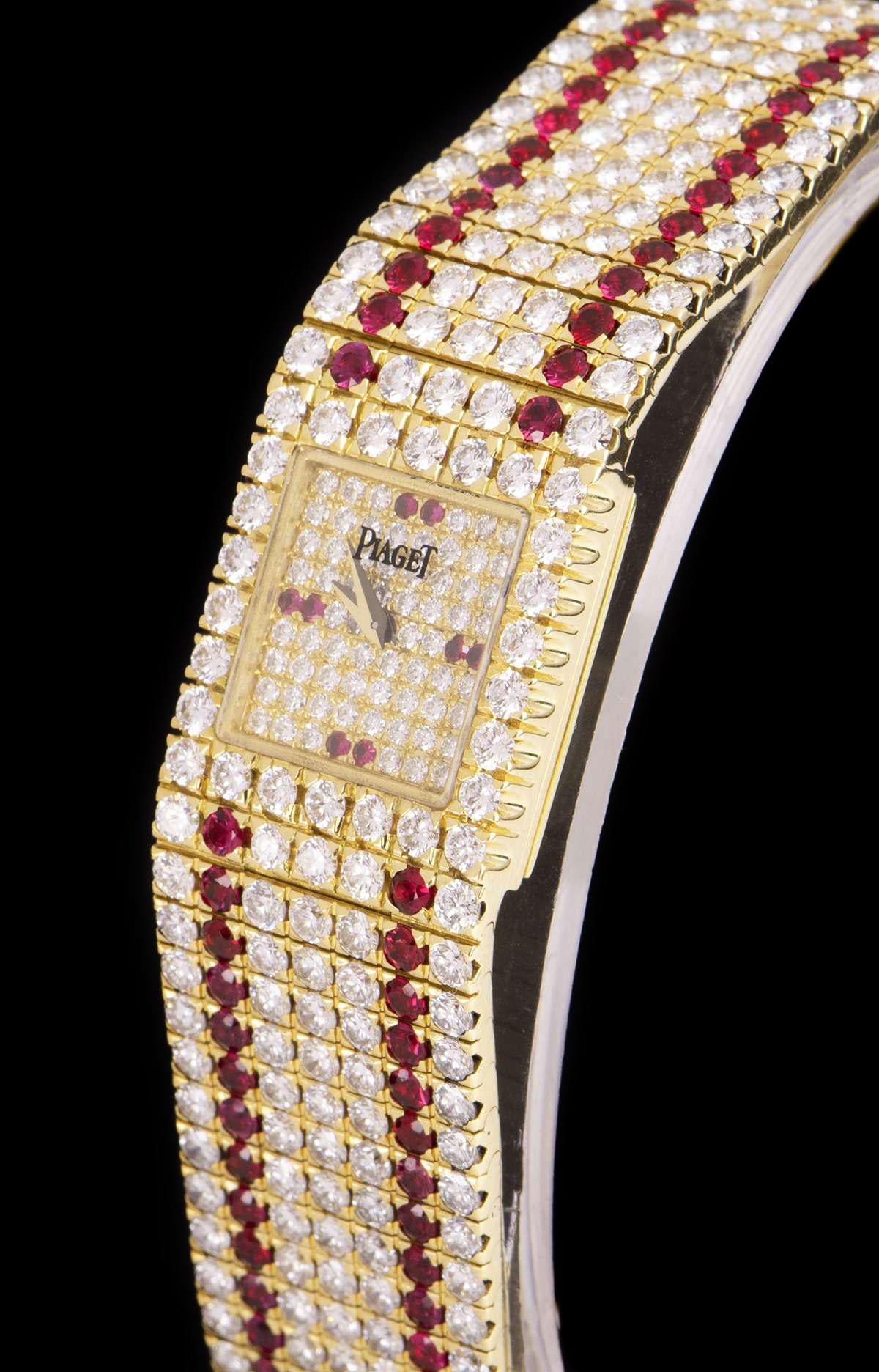 An 18k Yellow Gold Fully Loaded Vintage Ladies Wristwatch, pave diamond dial set with 2 round brilliant cut rubies at 3, 6, 9 and 12 0'clock, a fixed 18k yellow gold bezel set with 26 round brilliant cut diamonds, an 18k yellow gold jewellery style