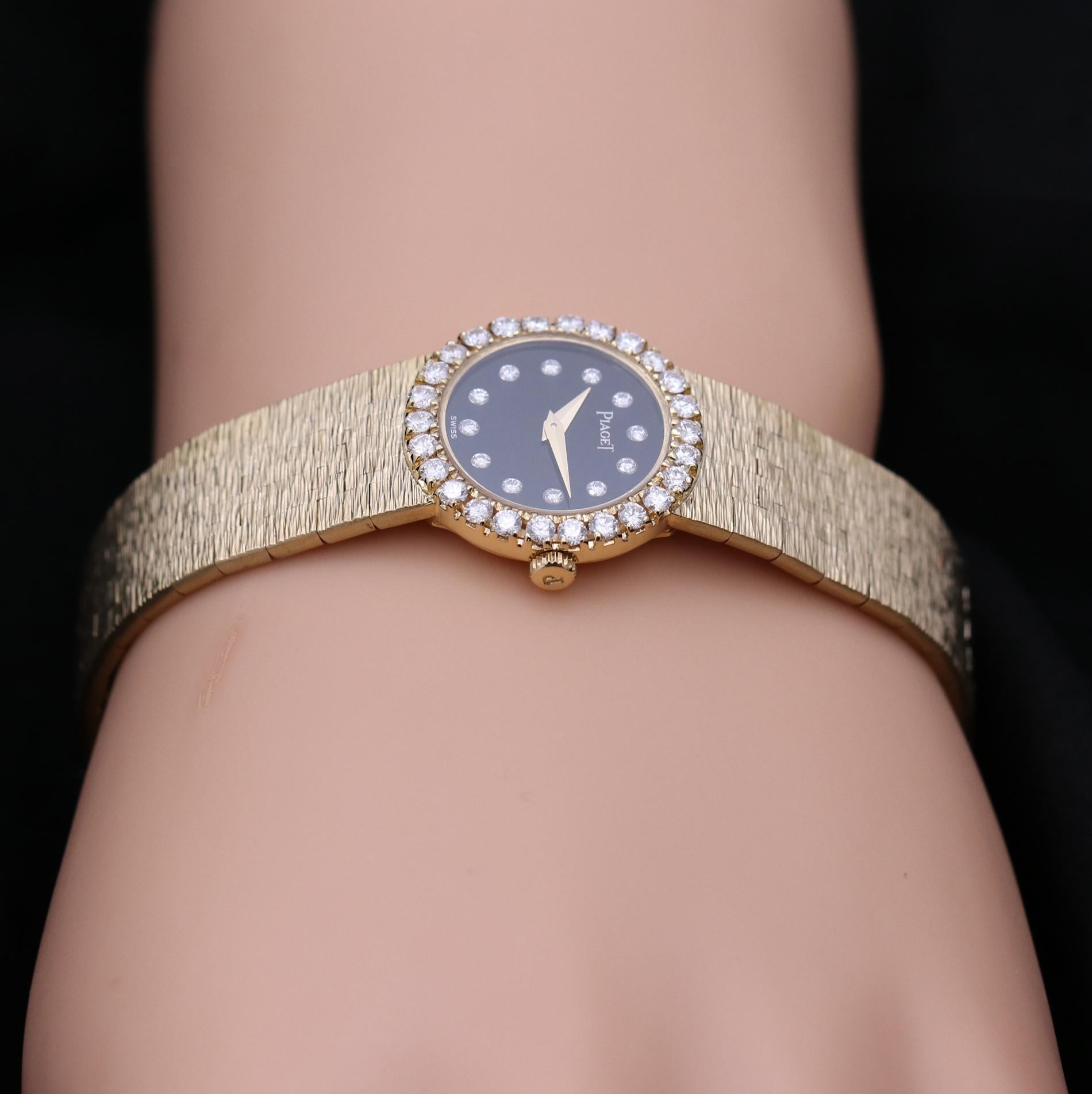 A ladies 18K yellow gold Piaget wristwatch set with 26 round brilliant cut diamonds in the bezel weighing a total of approximately 0.75ct. This petite mode features an onyx dial that is set with diamond markers weighing a total of approximately