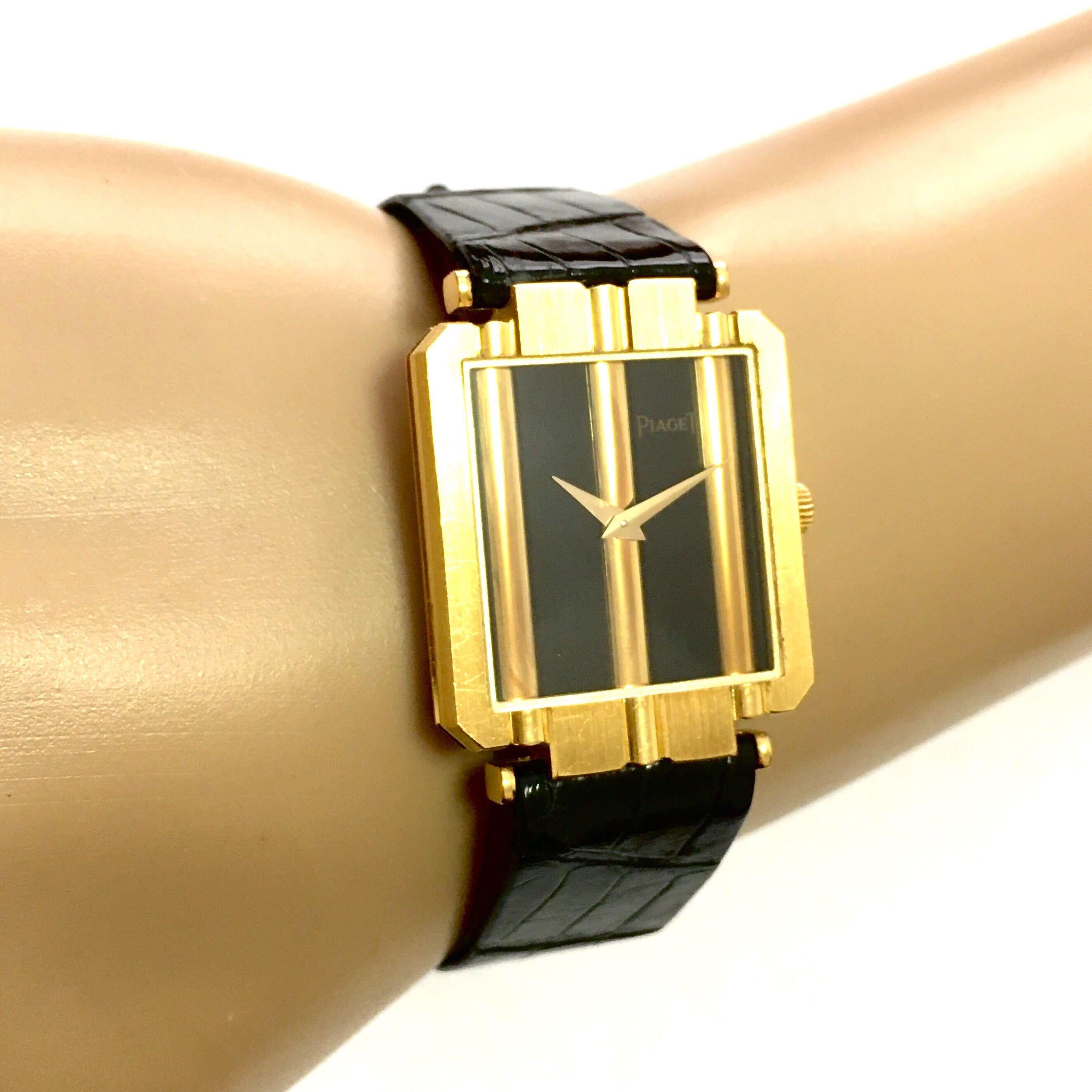 An 18 karat yellow gold watch. Piaget. Circa 1970. Of Quartz movement, 23m, the rectangular black dial, enhanced by gold lines, within a textured gold bezel, joined by a black leather band. Gross weight is approximately 32.6 grams, numbered 8113