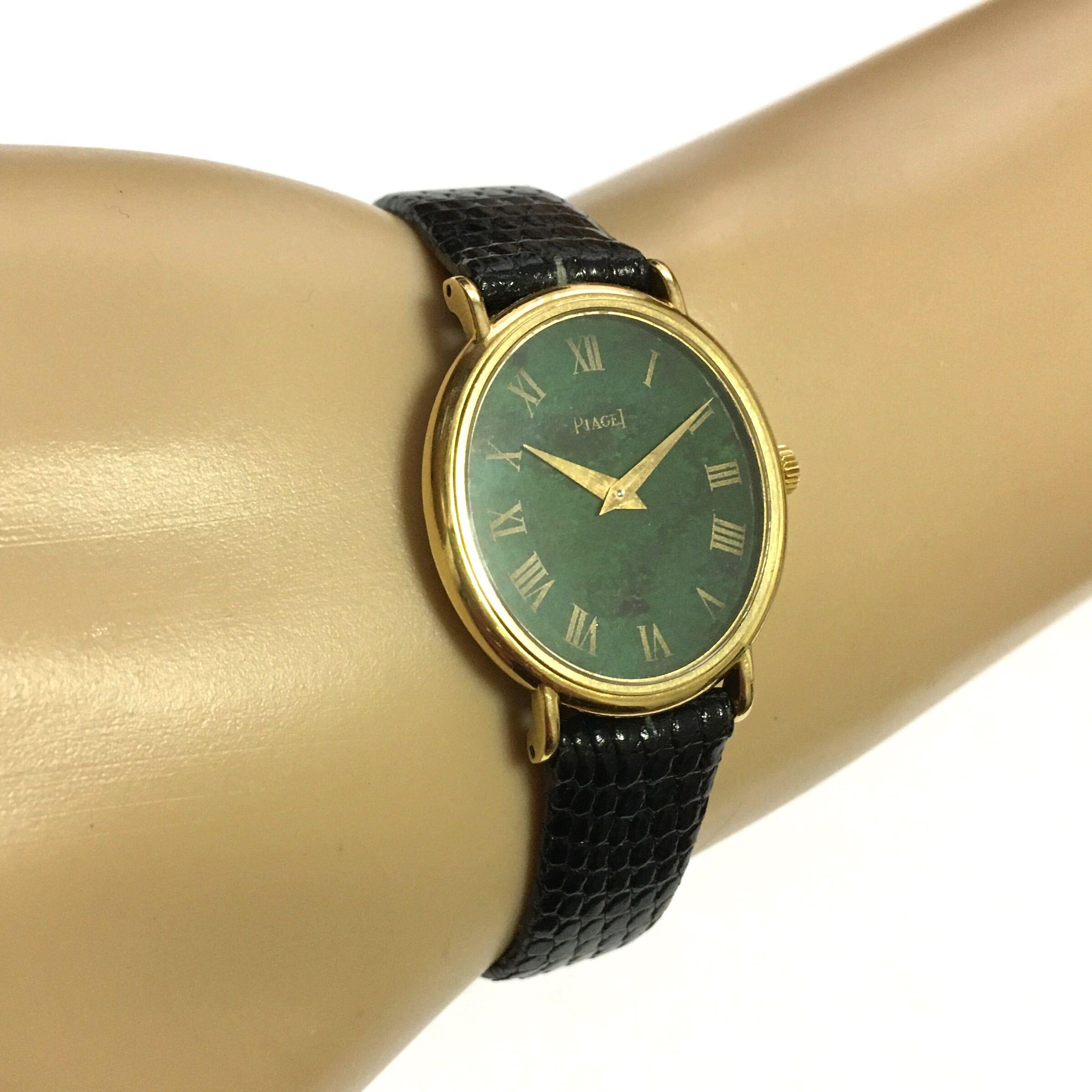 An 18 karat yellow gold and jade watch. Piaget. 24mm. Of mechanical movement, the oval jade dial with gold Roman numerals, with black leather band. Numbered 9822 1538510.