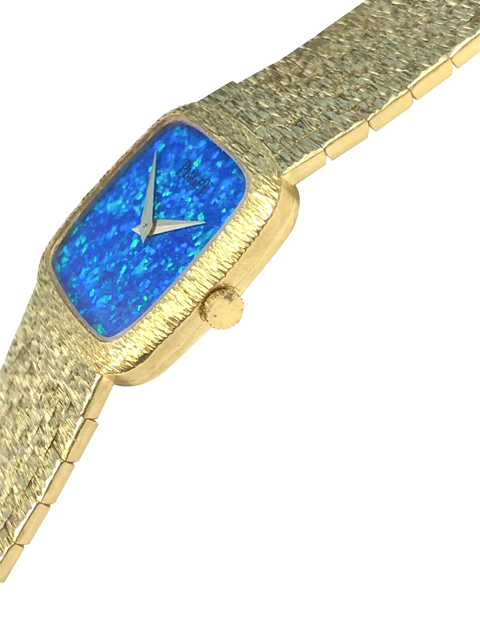 Circa 1980 Piaget Ladies Wrist Watch 23 X 23 M.M. Case with light textured finish, 17 Jewel Mechanical, Manual wind movement, Firey Opal dial, Gold hands.  5/8 inch wide textured bracelet measuring 6 1/4 inches in length. Recently serviced and comes