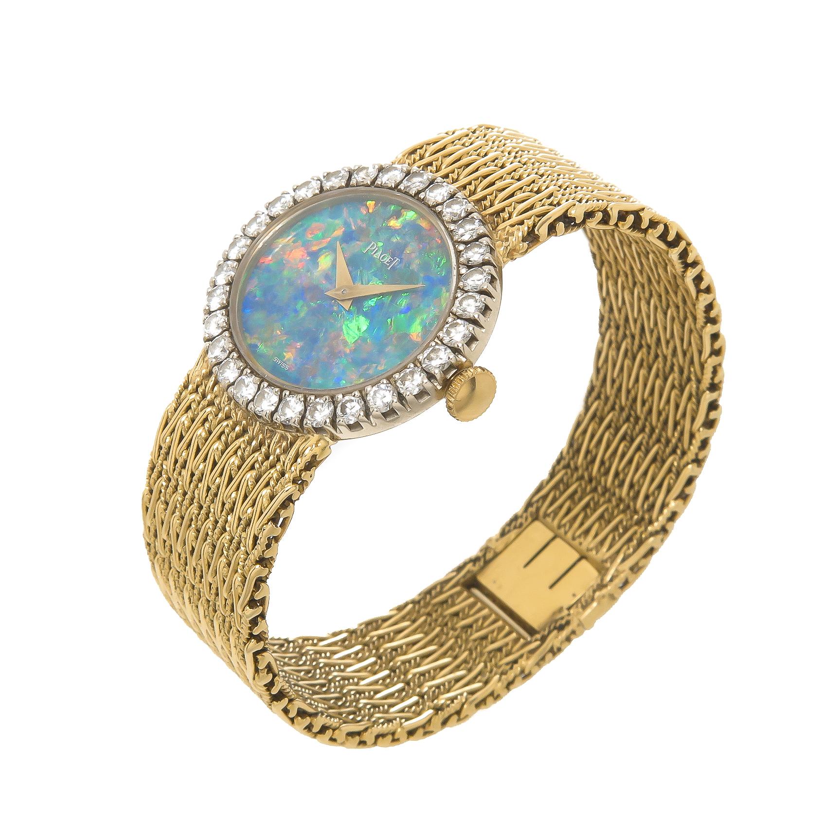 Circa 1980 Piaget Ladies Wrist watch, 27 X 24 MM 2 piece 18K Yellow Gold case. Piaget factory set Diamond bezel of round Brilliant cuts totaling 1 carat. 17 jewel mechanical, manual wind movement.  Boulder Opal dial with strong colors of Blue, Green