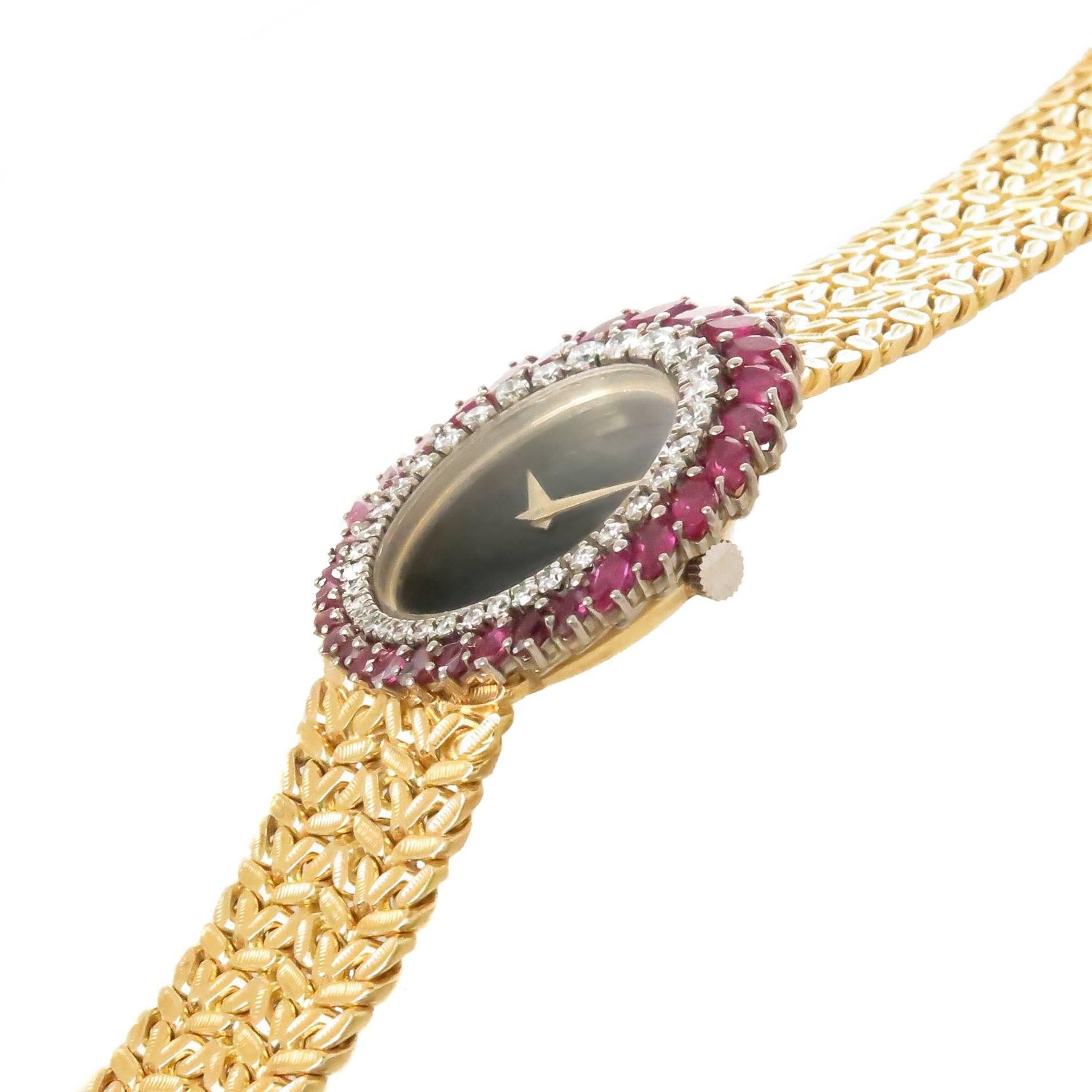 Circa 1970s Piaget Ladies Wrist Watch, 32 X 28 MM 18K Yellow Gold Oval Case, Diamond and Ruby set bezel, the diamonds taper in size and total just under 1 carat and further set with very fine color Marquis Rubies totaling over 2 carats. 17 Jewel