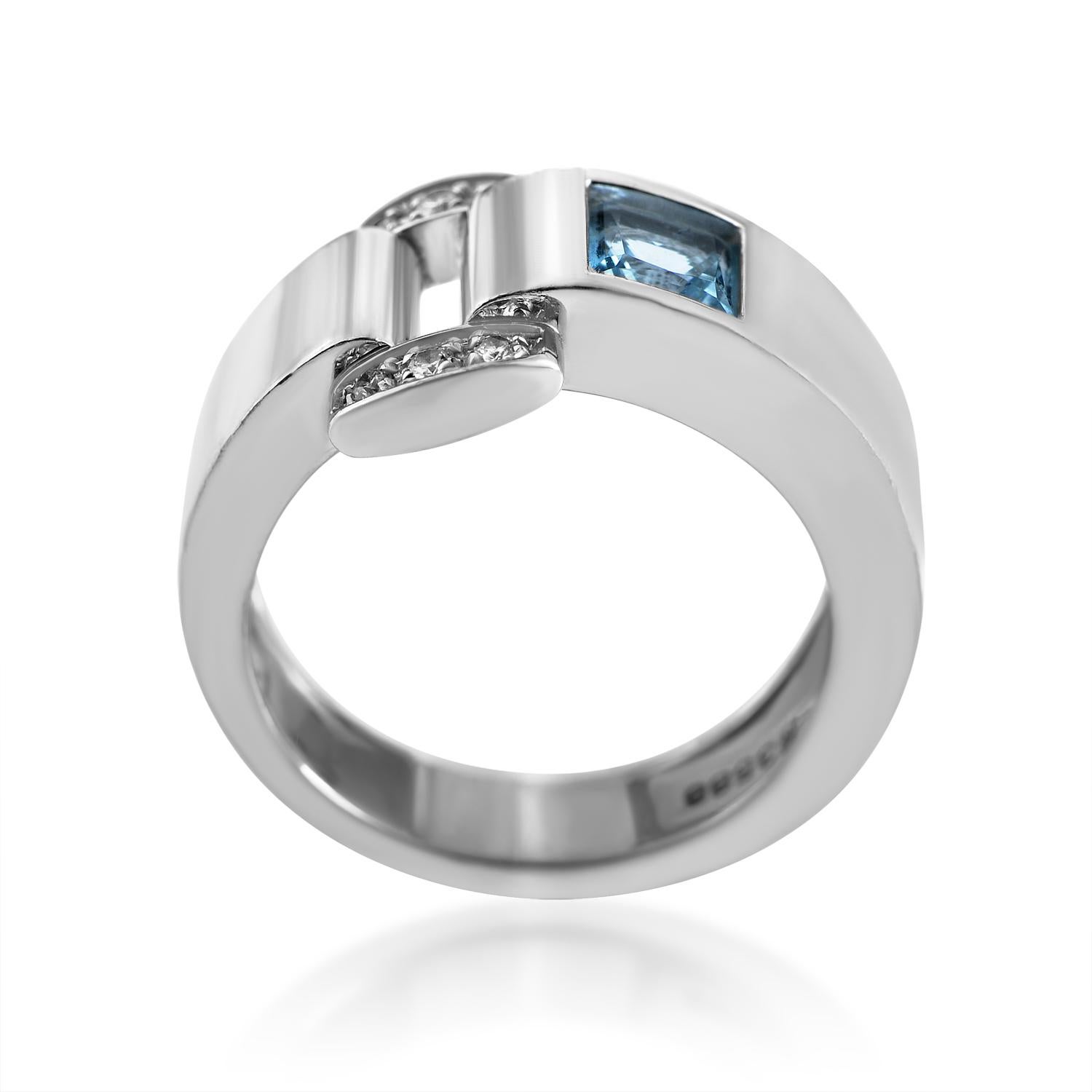 Piaget's Miss Protocole collection is renowned for its Sassy and sensual designs. This ring from the collection is made of 18K white gold and features a buckle-shaped accent set with .07ct of diamonds. Lastly, next to the buckle is a blue topaz