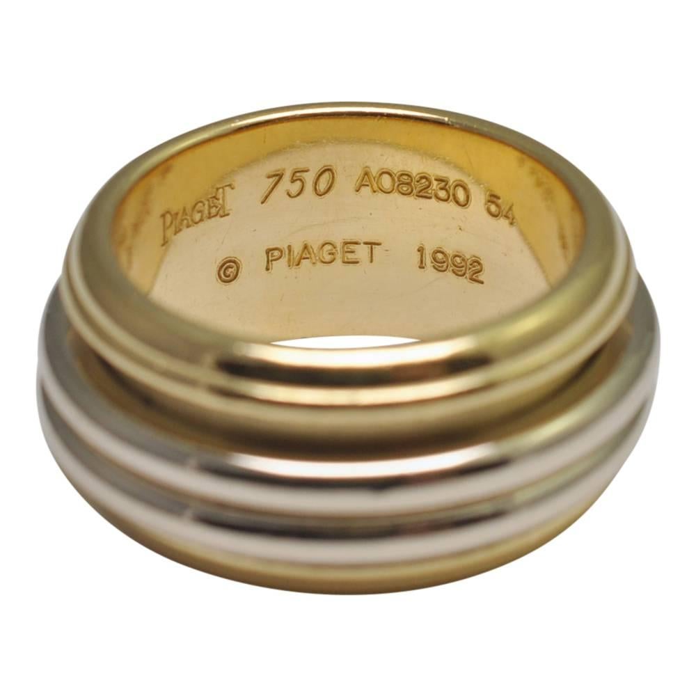 Piaget 'Possession' 18ct Yellow Gold ring set with two moving white gold bands:
Weight 16.4gms
Depth 10.08mm
The ring is substantial with a solid gold weight and is in excellent condition.  
Signed Piaget 750, 1992, numbered and stamped with the