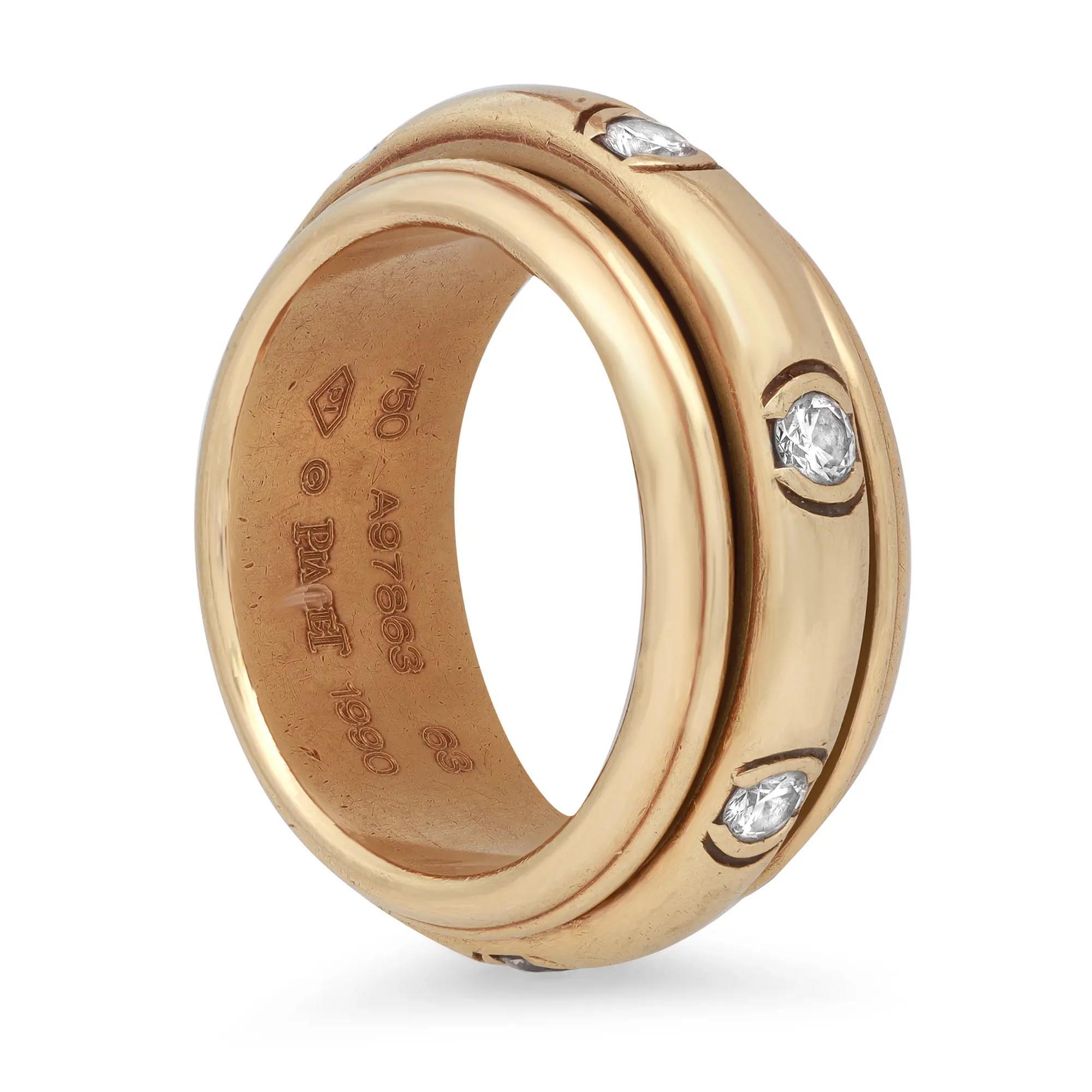 Piaget Possession diamond band ring. Crafted in fine 18K yellow gold. This ring features a wide band with a center moving band ring encrusted with 7 round brilliant cut diamonds weighing 1.05 carats approx. Signed Piaget. Date of manufacture 1990.